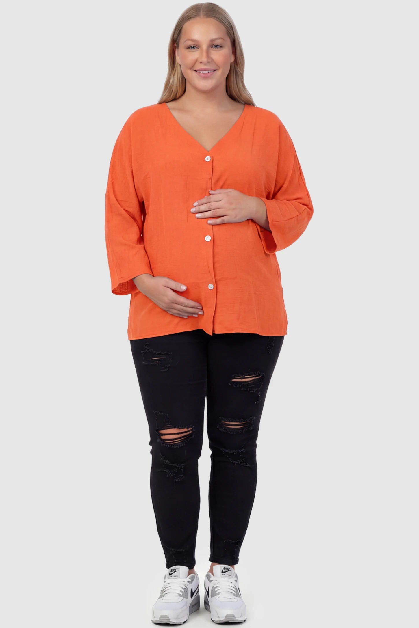 Button Down V-Neck Long Sleeve Maternity Top Button Down V-Neck Long Sleeve Maternity Top in Orange featuring a relaxed drape on a plus size pregnant model, front view.