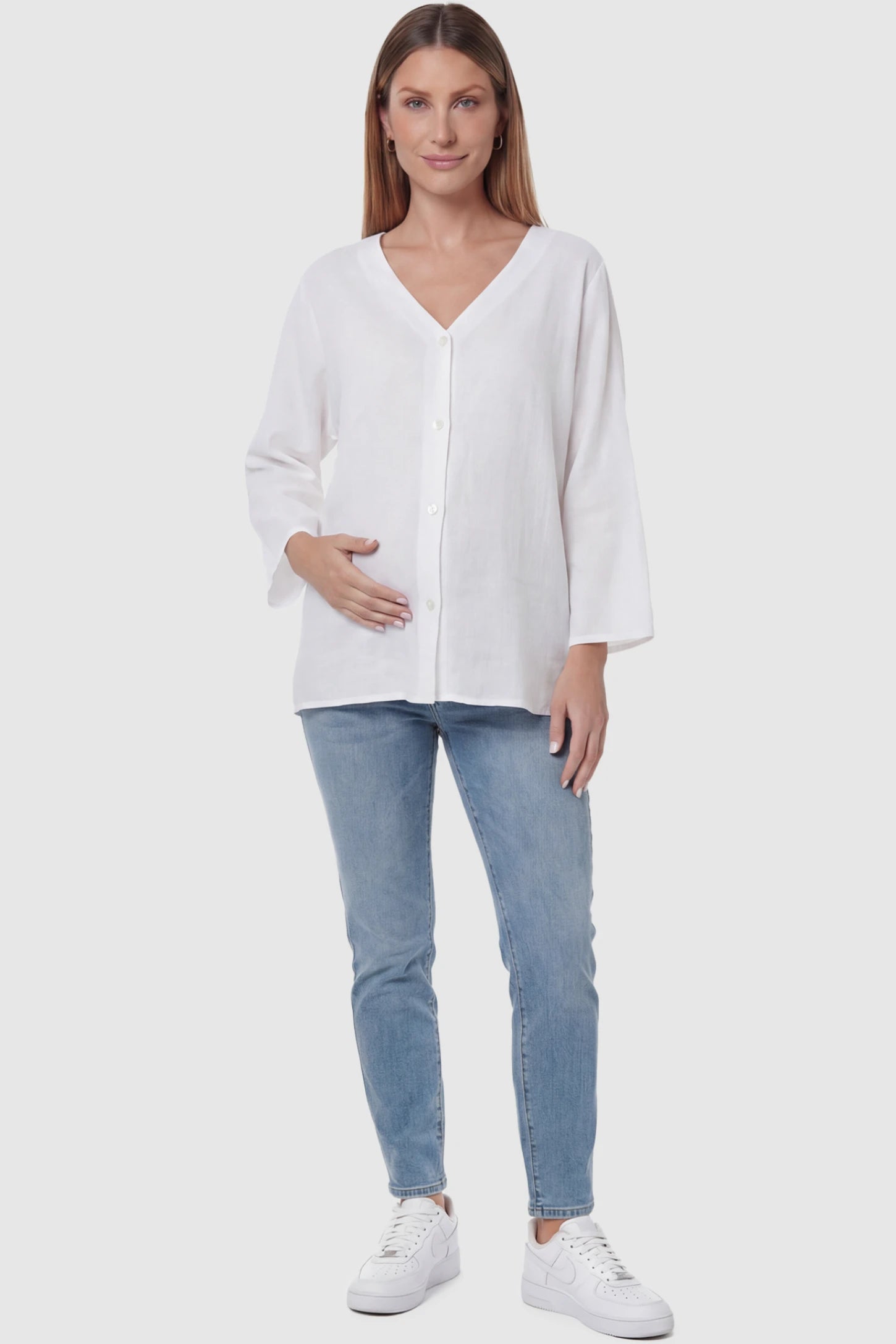 Button Down V-Neck Long Sleeve Maternity Top Button Down V-Neck Long Sleeve Maternity Top in White featuring a relaxed drape on a pregnant model, full body view.