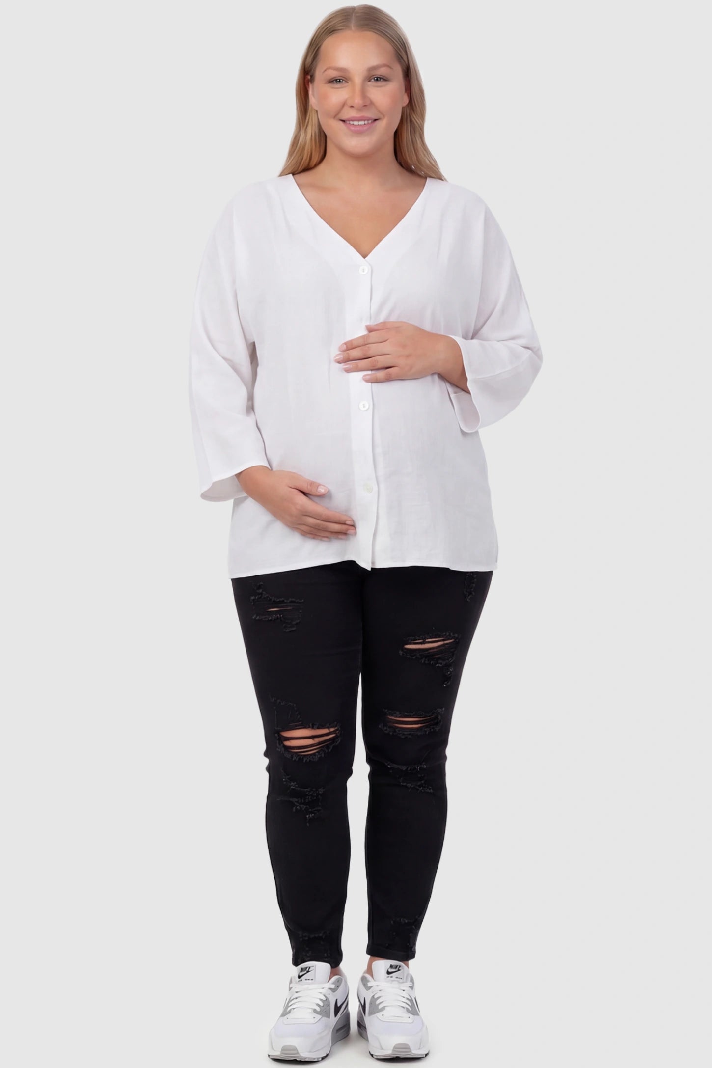 Button Down V-Neck Long Sleeve Maternity Top Button Down V-Neck Long Sleeve Maternity Top in White featuring a relaxed drape on a plus size pregnant model, front view.