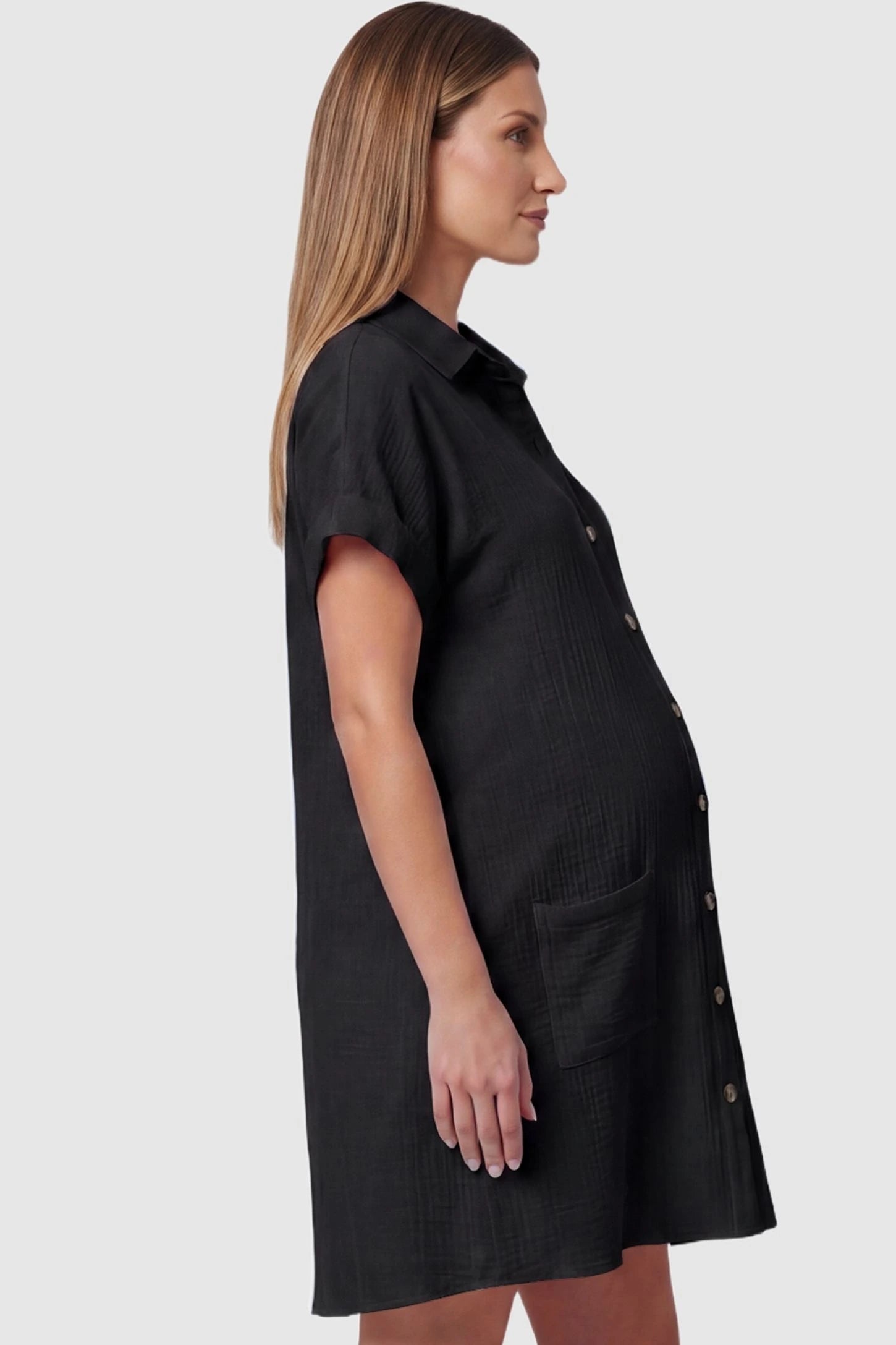 Breezy Button-Front Collared Nursing Dress Side view of Black Breezy Button-Front Collared Nursing Dress featuring room for a growing bump on a model.