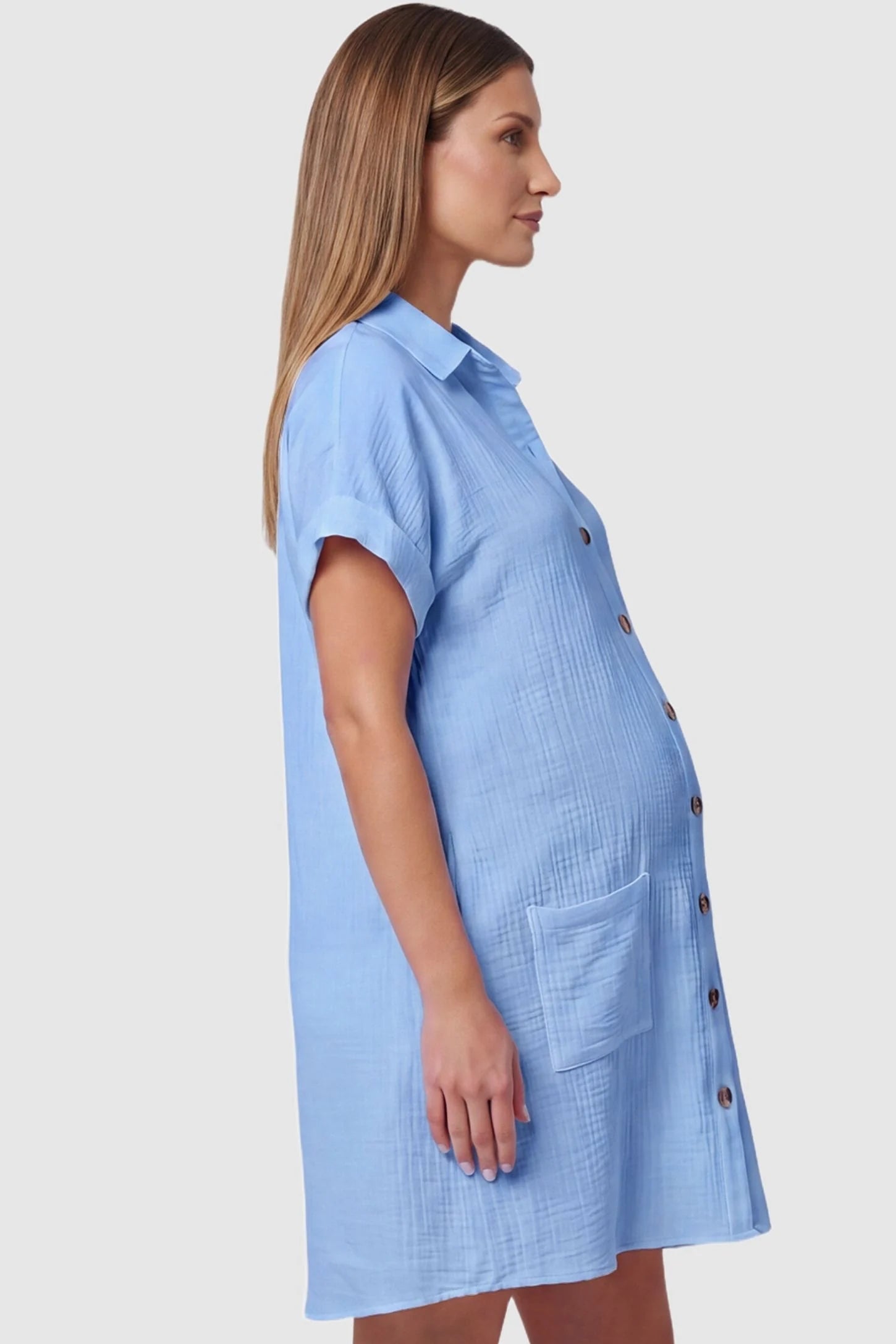 Breezy Button-Front Collared Nursing Dress Side view of Blue Breezy Button-Front Collared Nursing Dress featuring a curved hemline on a pregnant model.