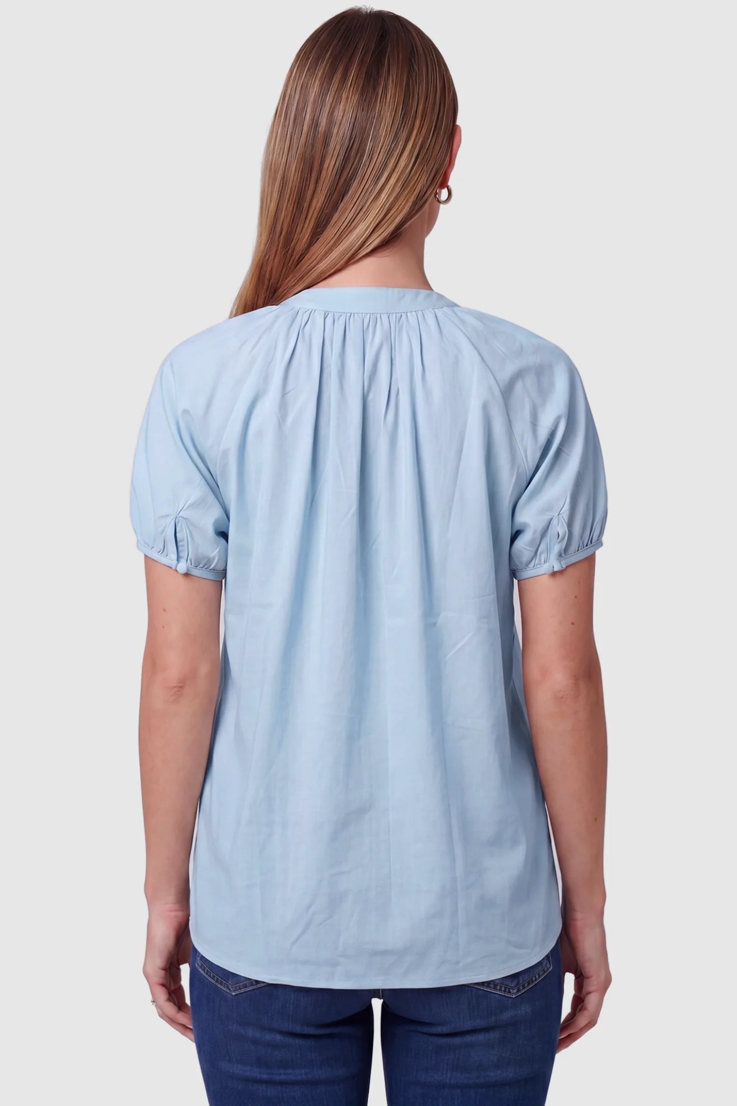 Button Front Short Sleeve Maternity Blouse Button Front Short Sleeve Maternity Blouse in Blue featuring gathered fabric and short sleeves on a pregnant model, back view.