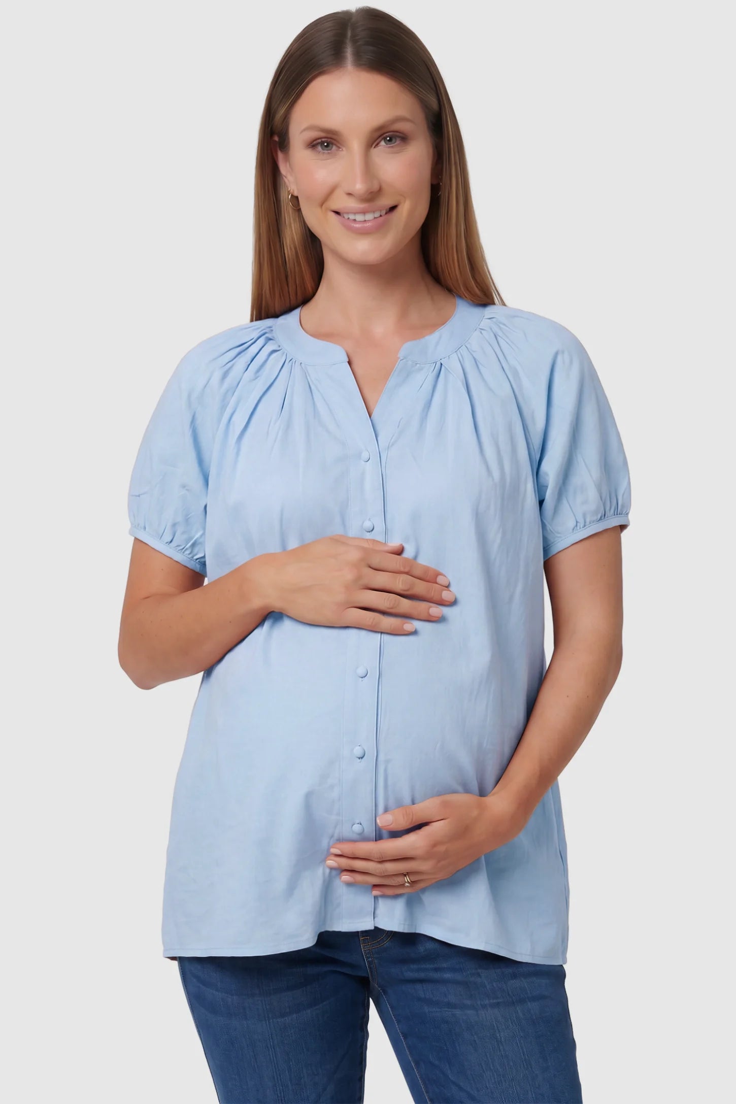 Button Front Short Sleeve Maternity Blouse Button Front Short Sleeve Maternity Blouse in Blue featuring gathered fabric and a button-up neck on a pregnant model, front view.