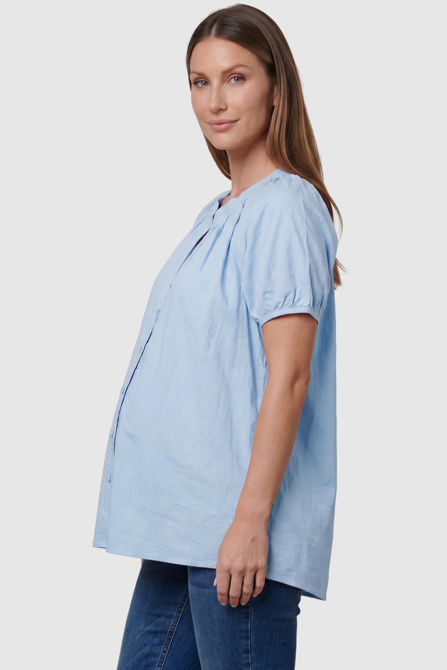 Button Front Short Sleeve Maternity Blouse Button Front Short Sleeve Maternity Blouse in Blue featuring gathered fabric and a button-up neck on a pregnant model, side view.