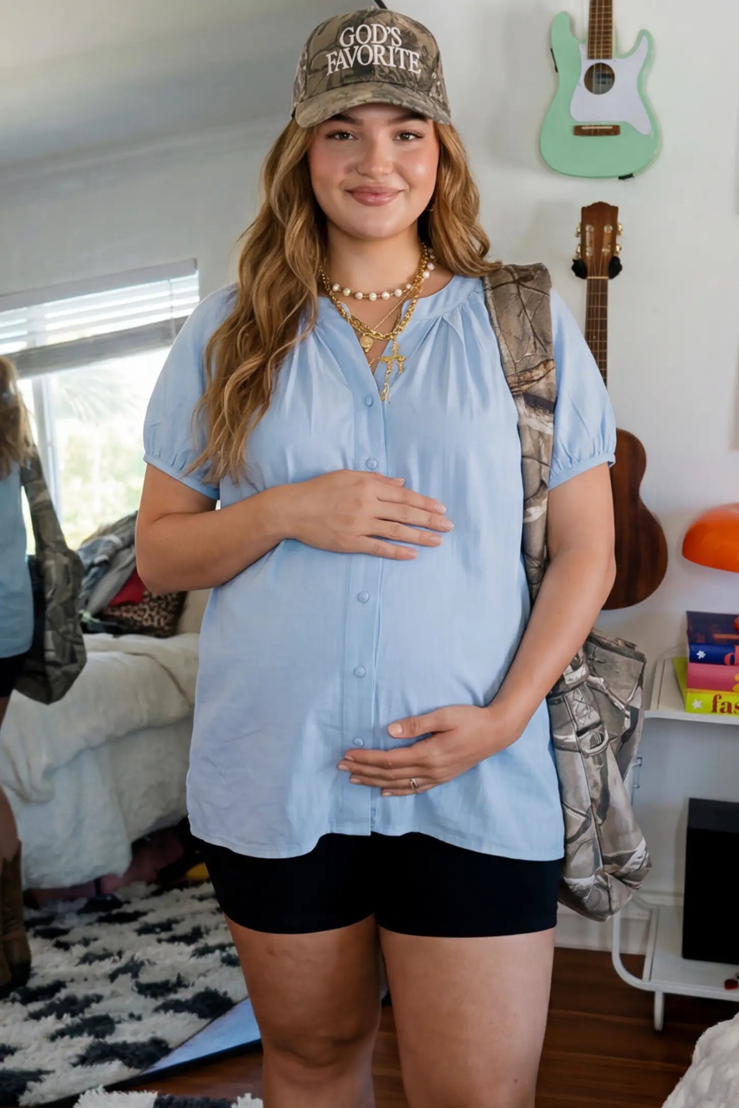 Button Front Short Sleeve Maternity Blouse Button Front Short Sleeve Maternity Blouse in Blue featuring gathered fabric and a button-up neck on a pregnant woman in indoor setting, front view.