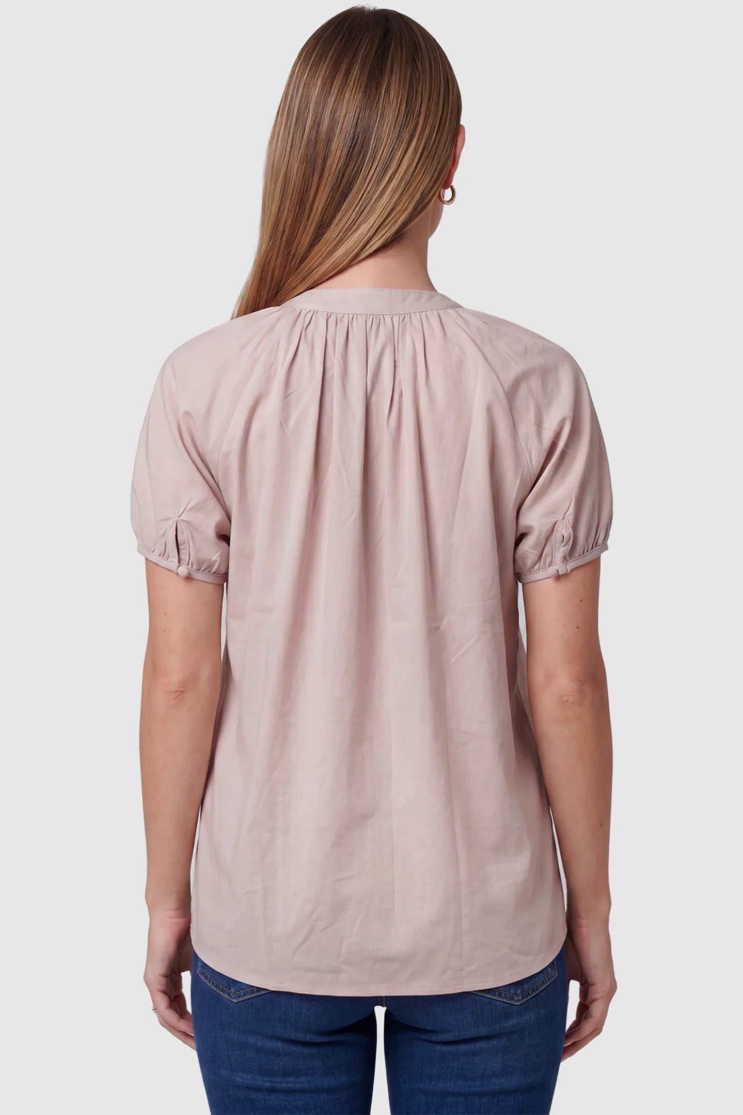 Button Front Short Sleeve Maternity Blouse Button Front Short Sleeve Maternity Blouse in Pink featuring gathered fabric and short sleeves on a pregnant model, back view.