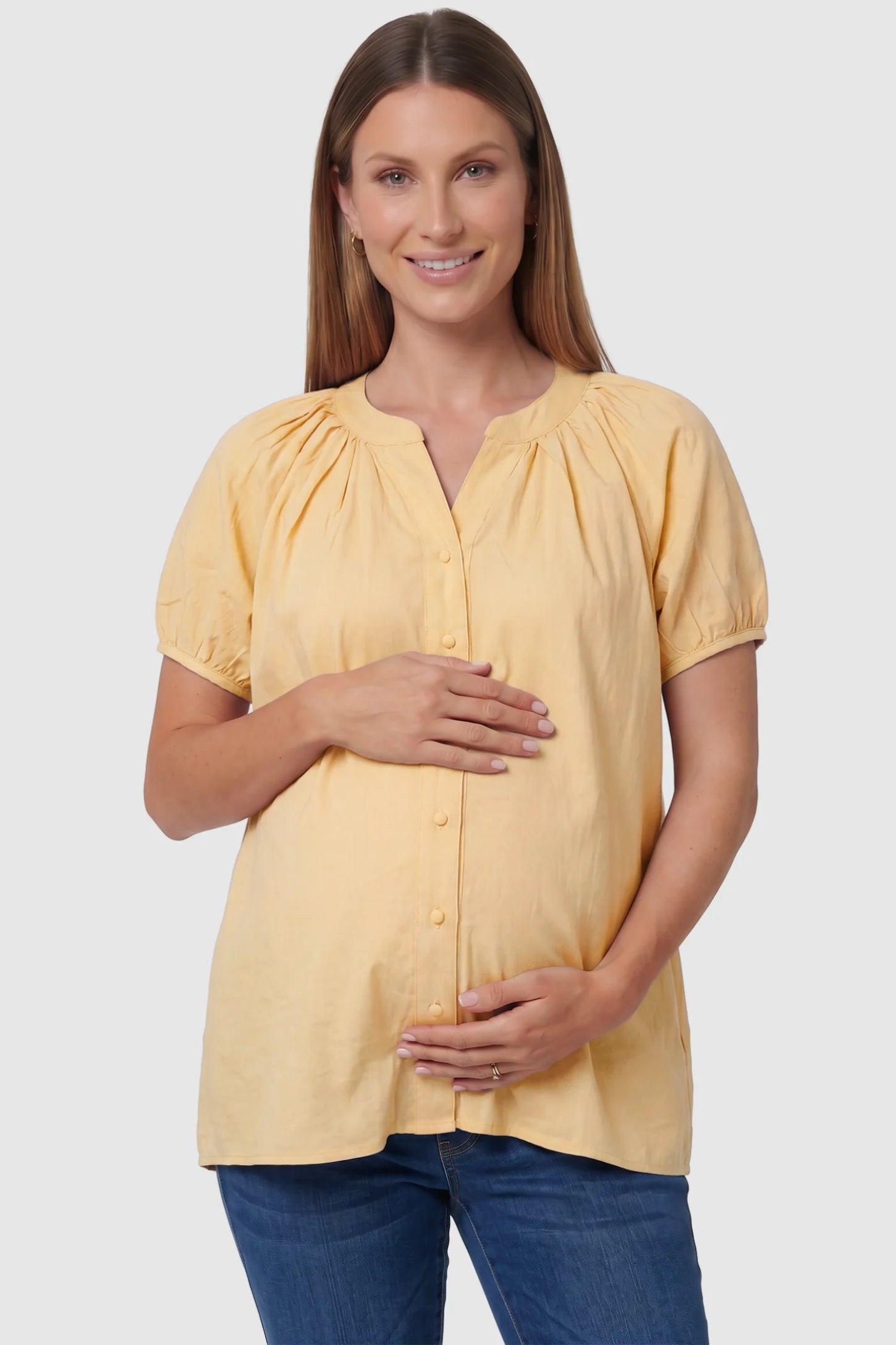 Button Front Short Sleeve Maternity Blouse Button Front Short Sleeve Maternity Blouse in Yellow featuring gathered fabric and a button-up neck on a pregnant model, front view.
