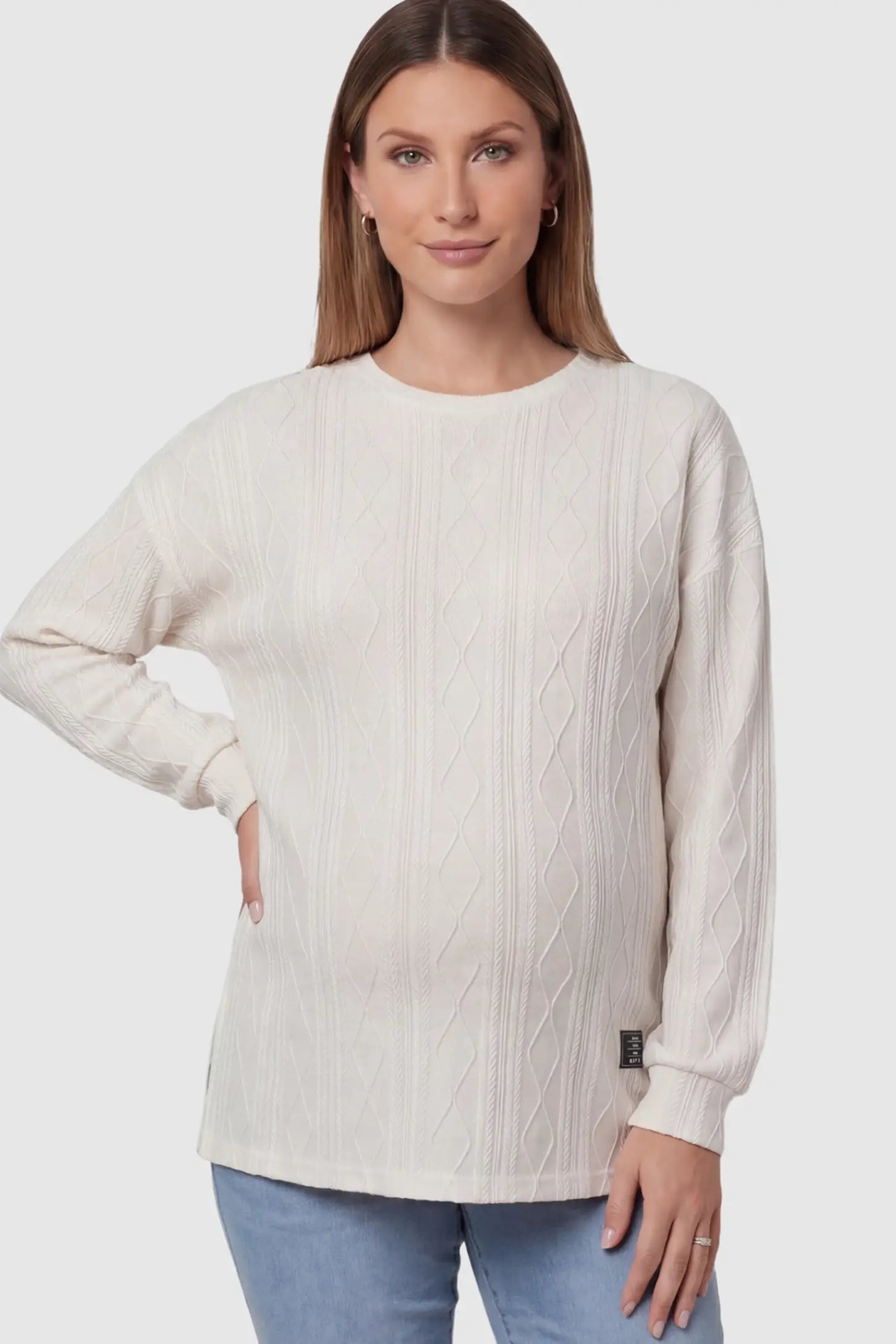 Cable Knit Long Sleeve Maternity Sweater in apricot featuring a breathable textured weave on a pregnant model showing front.