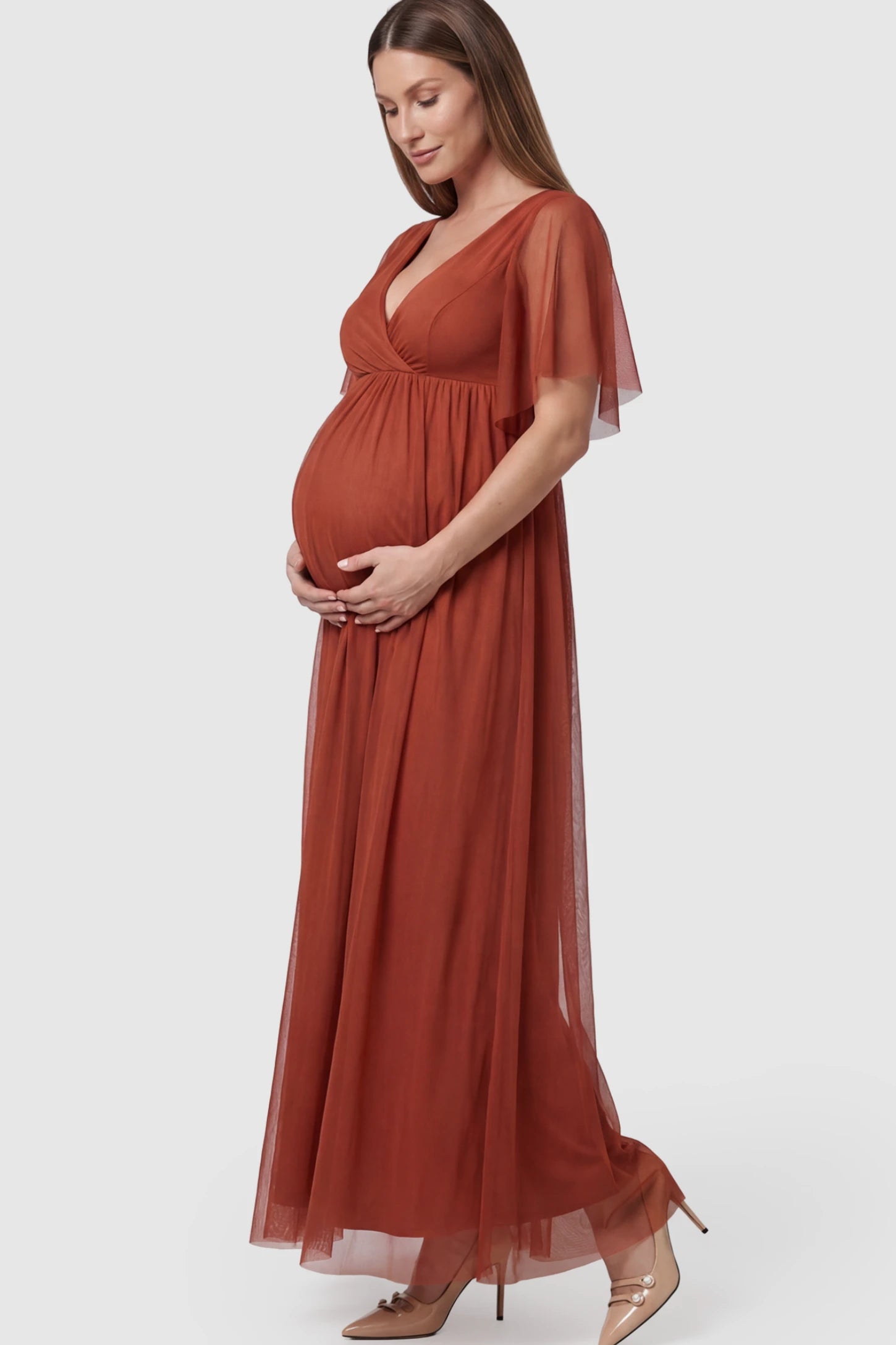 Chiffon Flutter Sleeve V-Neck Maternity Maxi Dress Chiffon Flutter Sleeve V-Neck Maternity Maxi Dress in Rust featuring a mesh overlay on a pregnant model showing side.