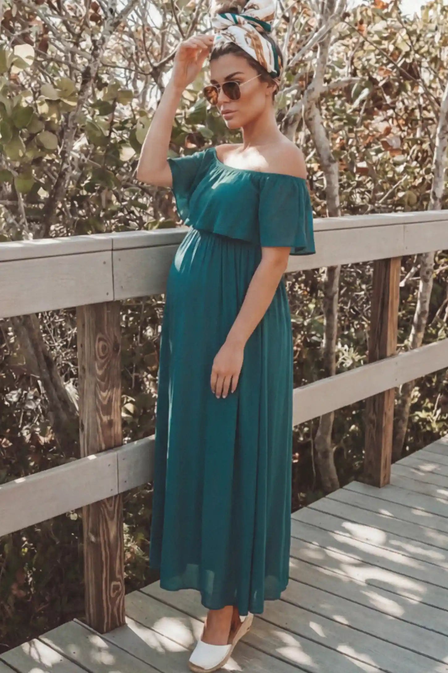 Chiffon Off Shoulder Maternity Maxi Dress Chiffon Off-Shoulder Maternity Maxi Dress in green featuring a Floor-length on a pregnant woman showing side.