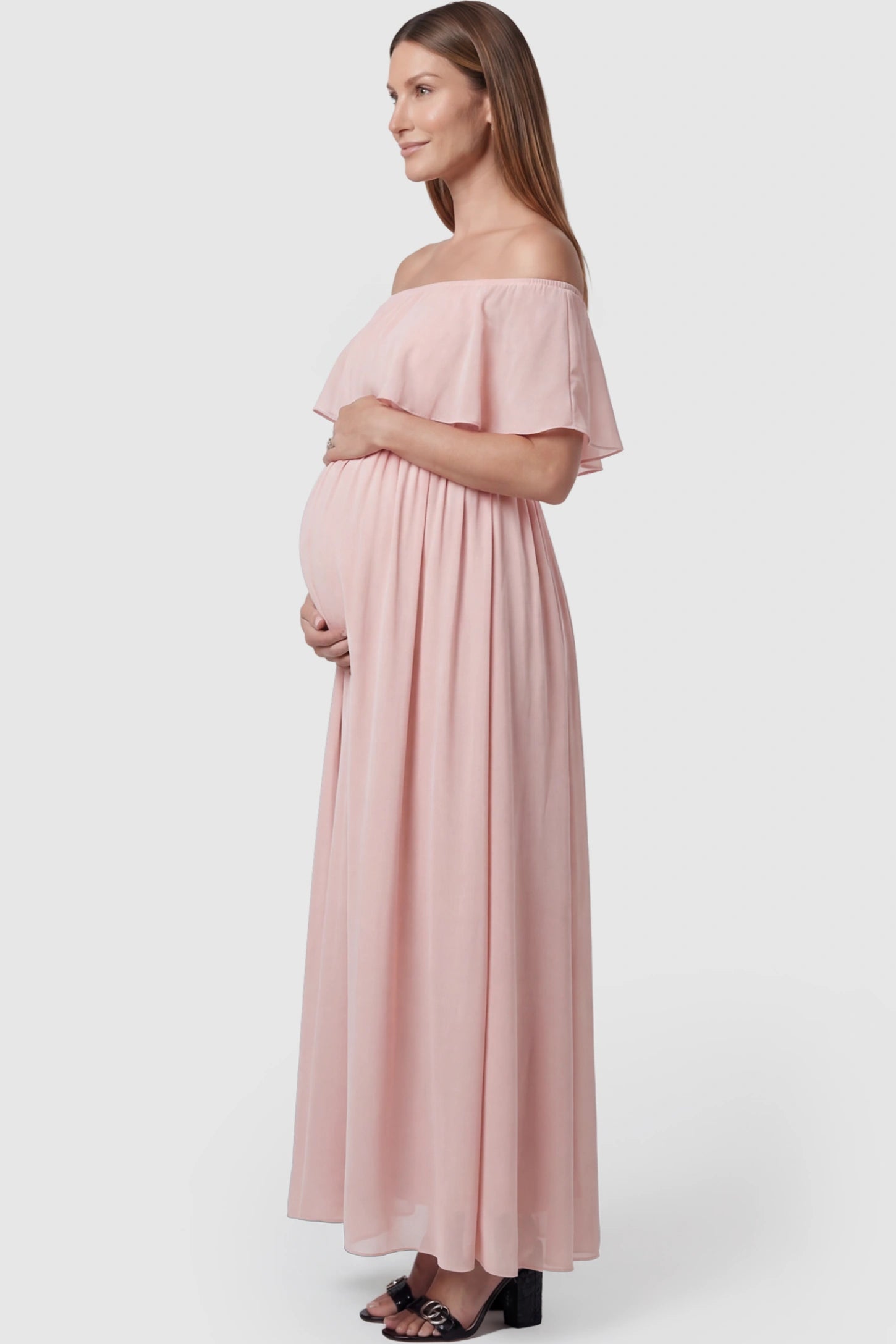 Chiffon Off Shoulder Maternity Maxi Dress Chiffon Off-Shoulder Maternity Maxi Dress in Pink featuring a Floor-length on a pregnant model showing side.