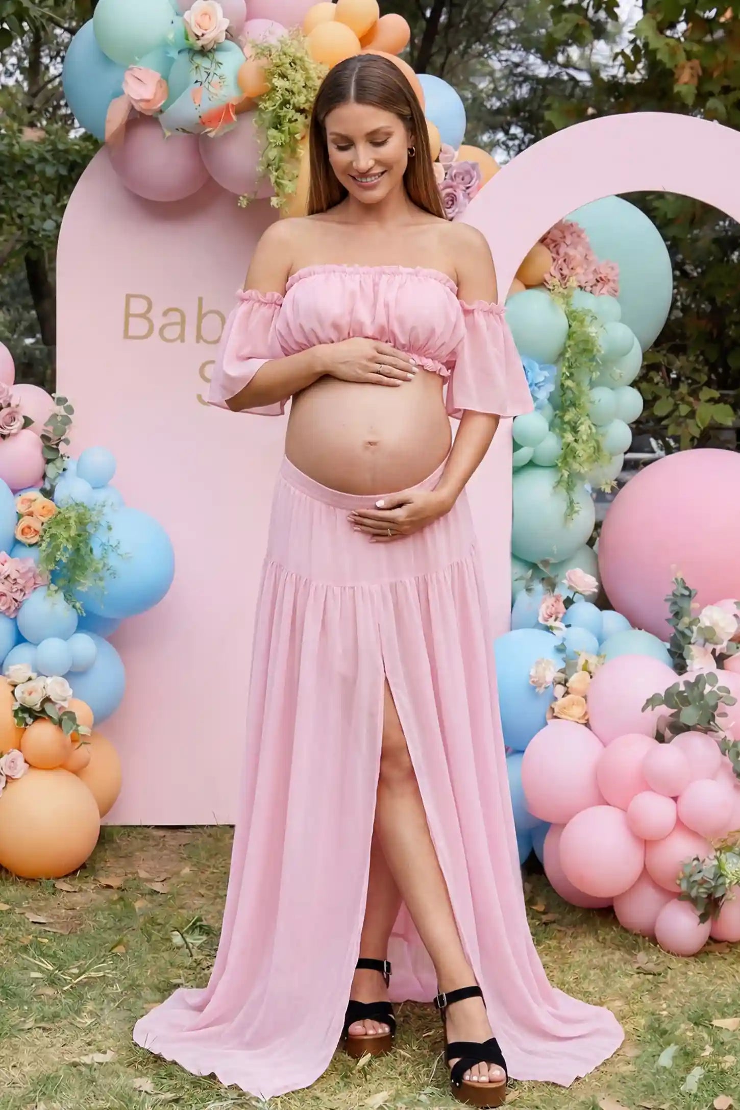 Chiffon Ruffle Off-Shoulder Two-Piece Maxi Maternity Dress Chiffon Ruffle Off-Shoulder Two-Piece Maxi Maternity Dress in Pink featuring a ruffled off-shoulder neckline on a pregnant model, front view.