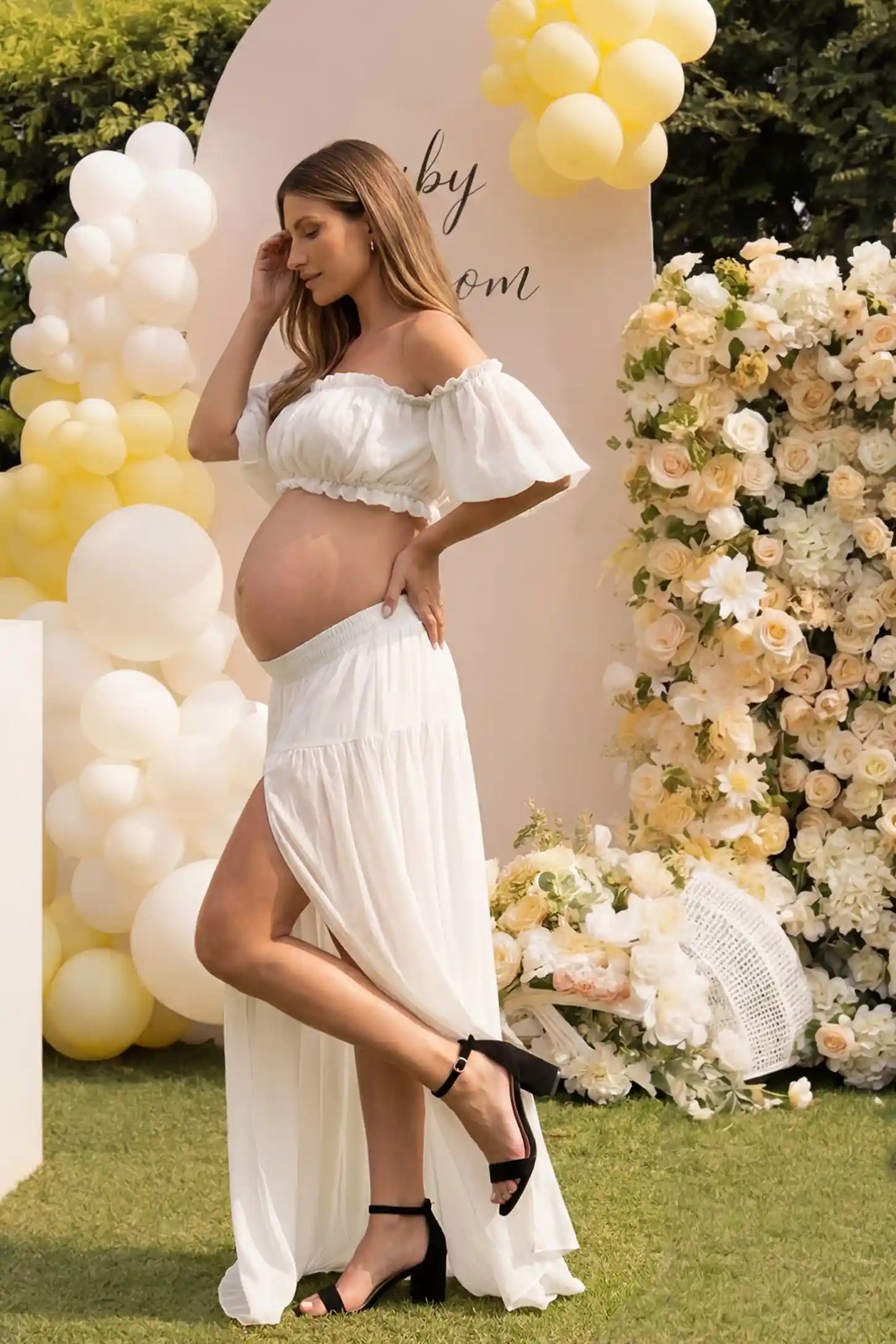 Chiffon Ruffle Off-Shoulder Two-Piece Maxi Maternity Dress Chiffon Ruffle Off-Shoulder Two-Piece Maxi Maternity Dress in White featuring a flowy thigh-high slit skirt on a pregnant model, side view.