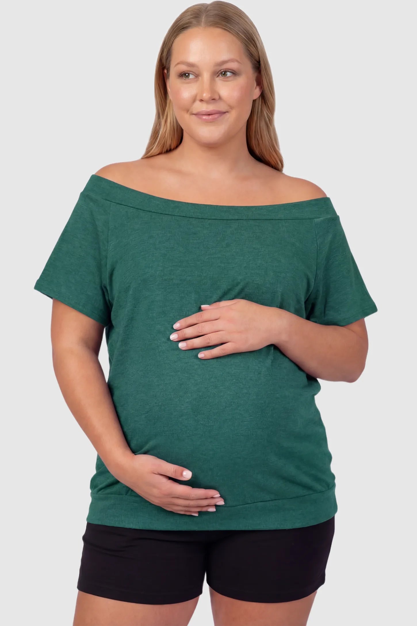 Convertible Neck Short Sleeve Maternity Top Convertible Neck Short Sleeve Maternity Top in green featuring an adjustable neckline and a comfortable banded hem on a plus size pregnant model front view.