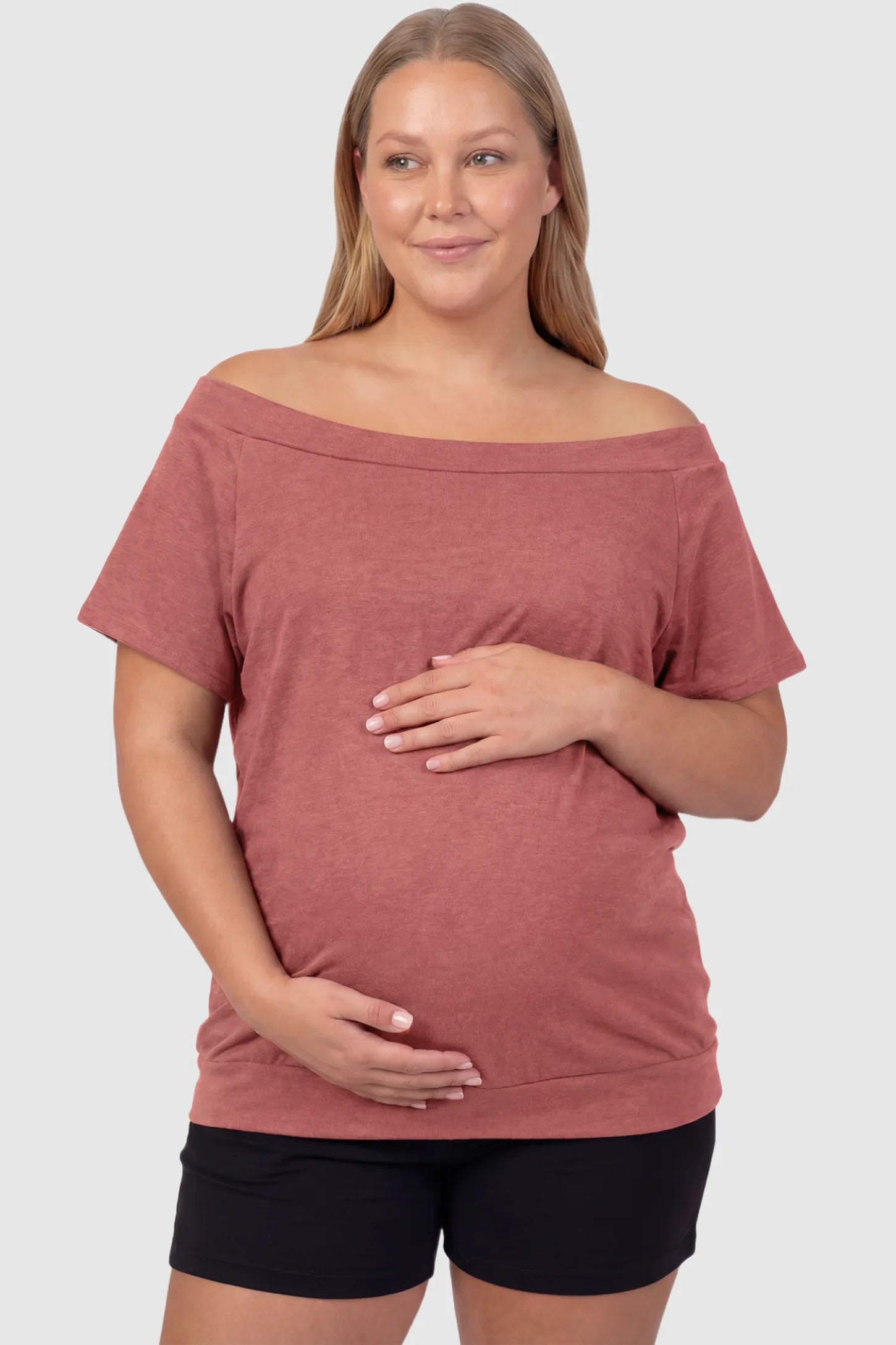 Convertible Neck Short Sleeve Maternity Top Convertible Neck Short Sleeve Maternity Top in pink featuring an adjustable neckline and a comfortable banded hem on a plus size pregnant model front view.