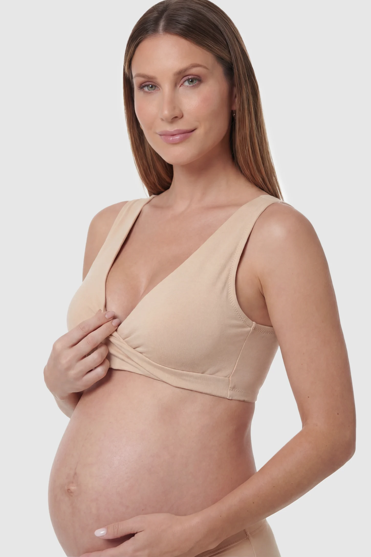 Cotton Blend Crossover Maternity Nursing Bra Cotton Blend Crossover Maternity Nursing Bra in Skin featuring a wire-free wrap front on a pregnant model showing detail.