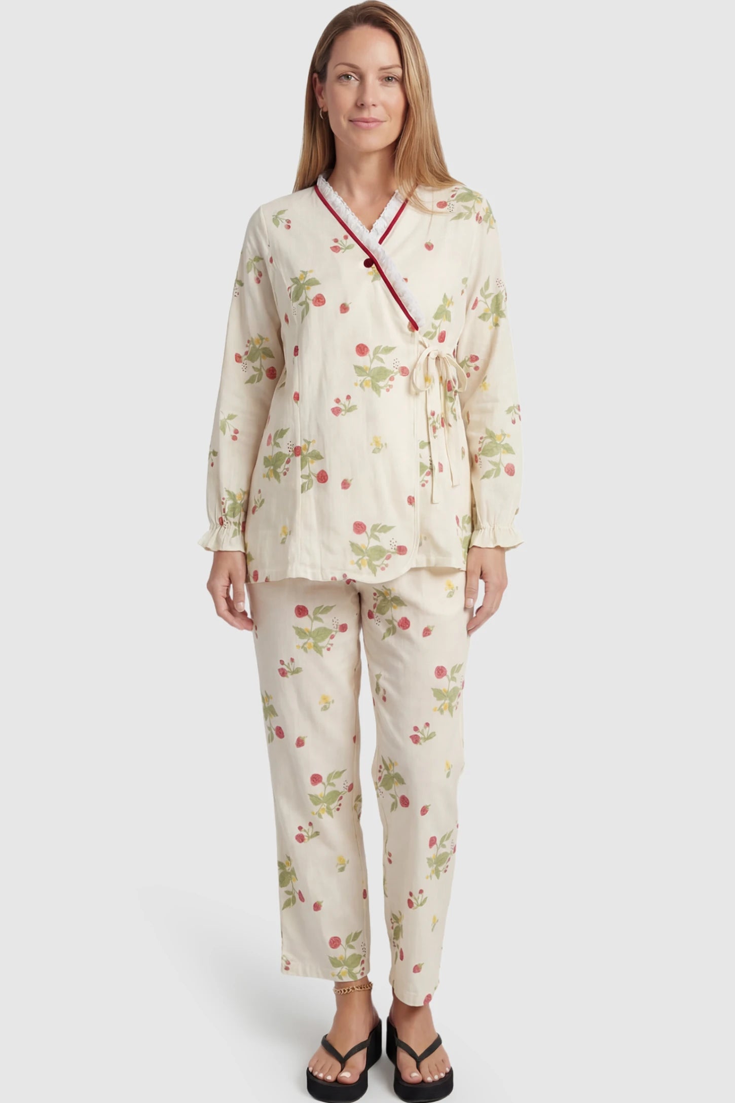 Cotton Long Sleeve Top & Pants Maternity Pajama Set Cotton Long Sleeve Maternity Pajama Set in Strawberry Cream Print featuring a wrap-style top and lace trim on a postpartum model showing front.