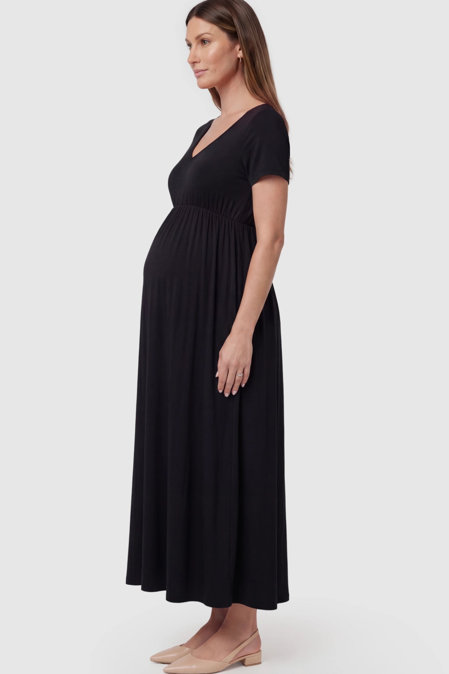 Cotton V-Neck Short Sleeve Maternity Maxi Dress Solid V-Neck Maxi Maternity Dress in black featuring breathable cotton and a deep neckline on a pregnant model showing side.