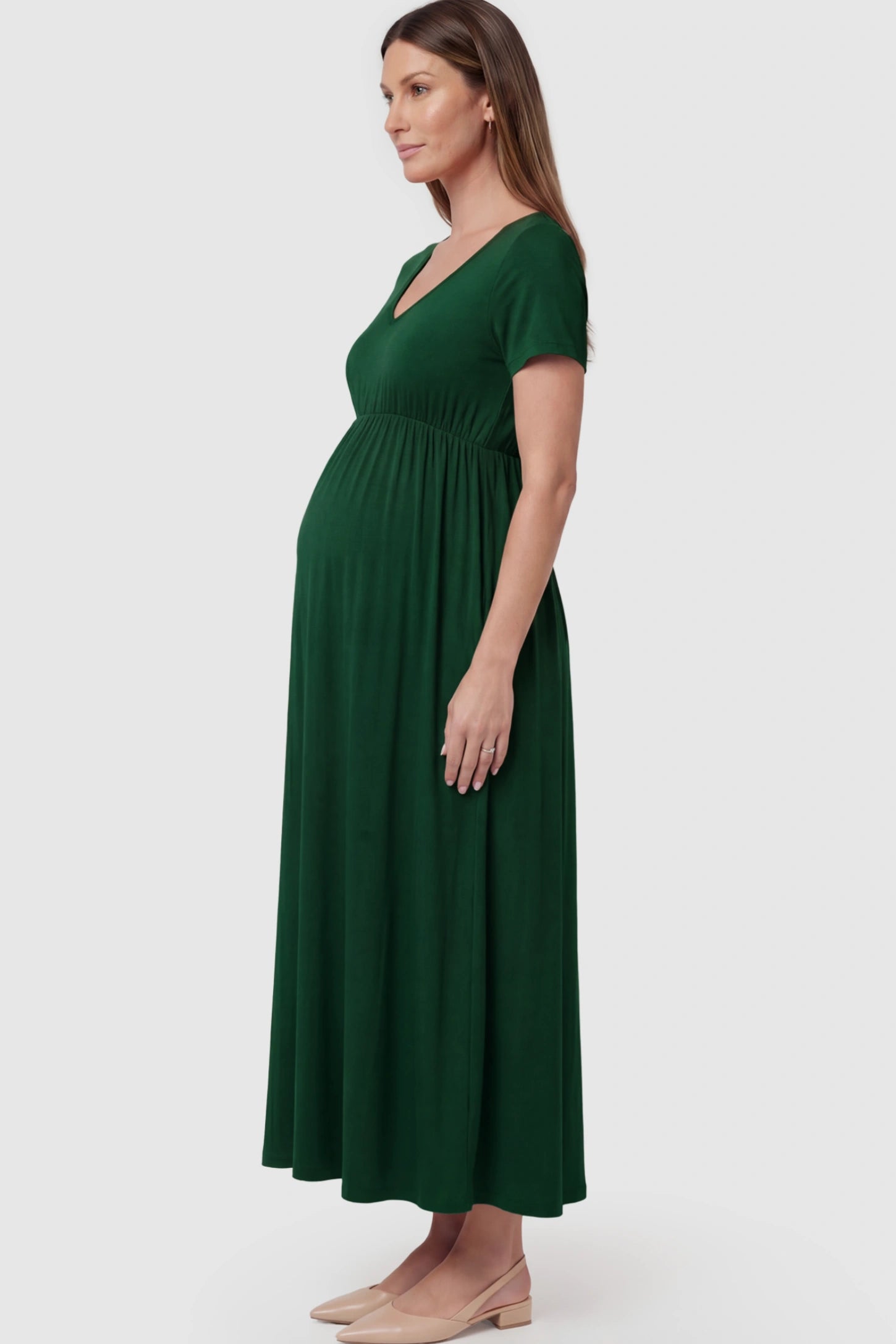 Cotton V-Neck Short Sleeve Maternity Maxi Dress Solid V-Neck Maxi Maternity Dress in dark green featuring breathable cotton and a deep neckline on a pregnant model showing side.