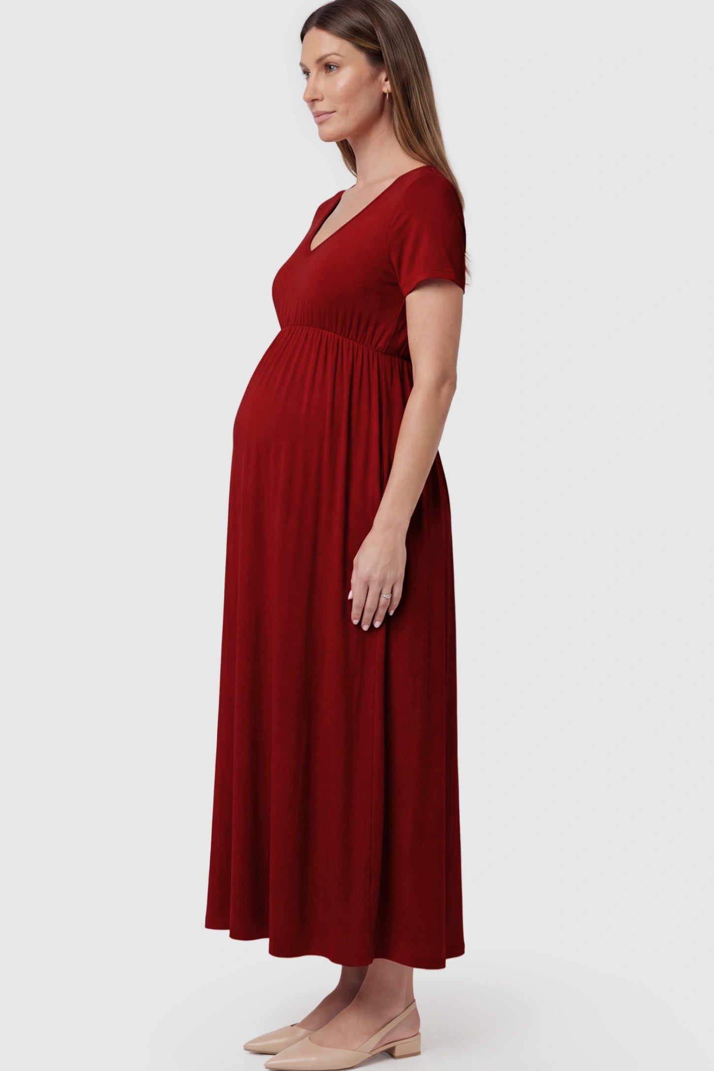 Cotton V-Neck Short Sleeve Maternity Maxi Dress Solid V-Neck Maxi Maternity Dress in dark red featuring breathable cotton and a deep neckline on a pregnant model showing side.