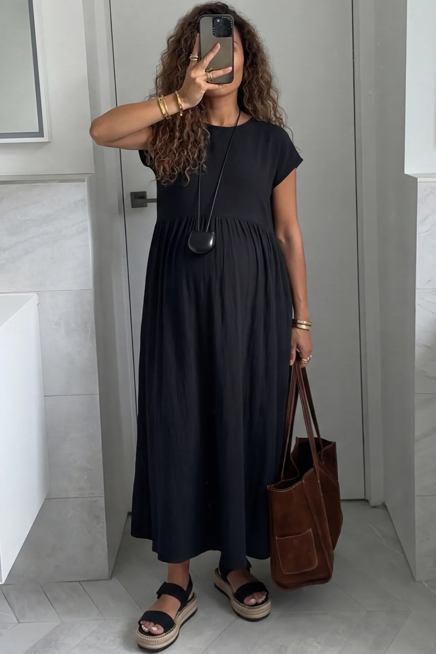 Crew Neck Short Sleeve Maternity Midi Dress Crew Neck Short Sleeve Maternity Midi Dress in Black featuring a flowy shift silhouette on a pregnant woman, front view.