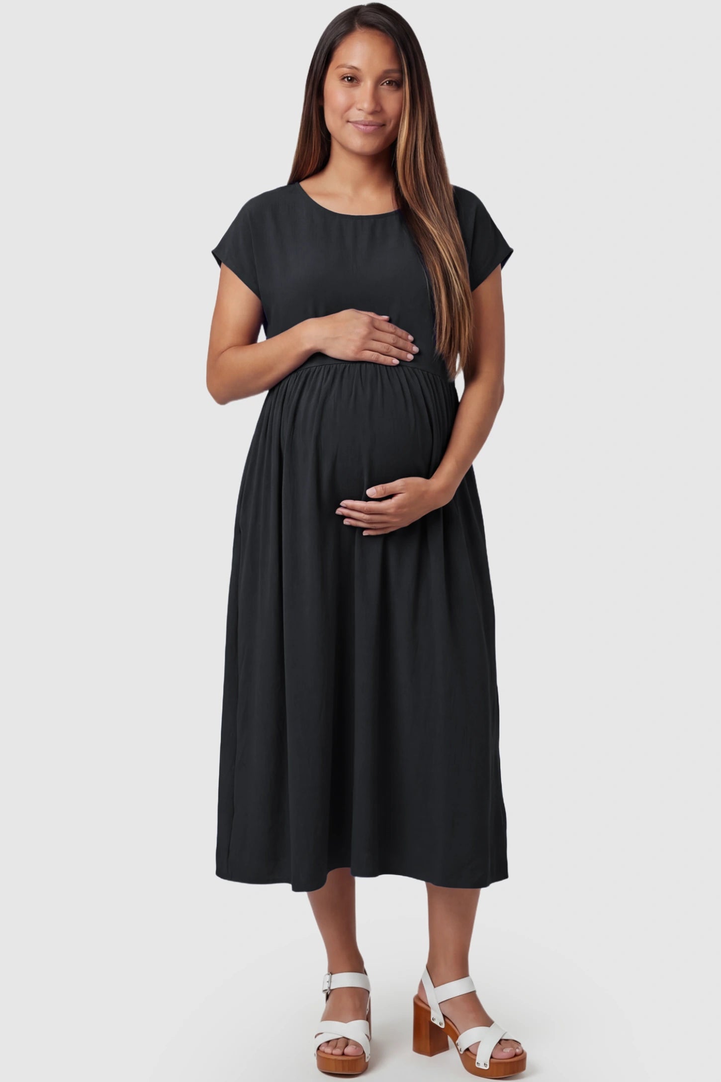 Crew Neck Short Sleeve Maternity Midi Dress Crew Neck Short Sleeve Maternity Midi Dress in Black featuring a flowy shift silhouette on a pregnant model, front view.