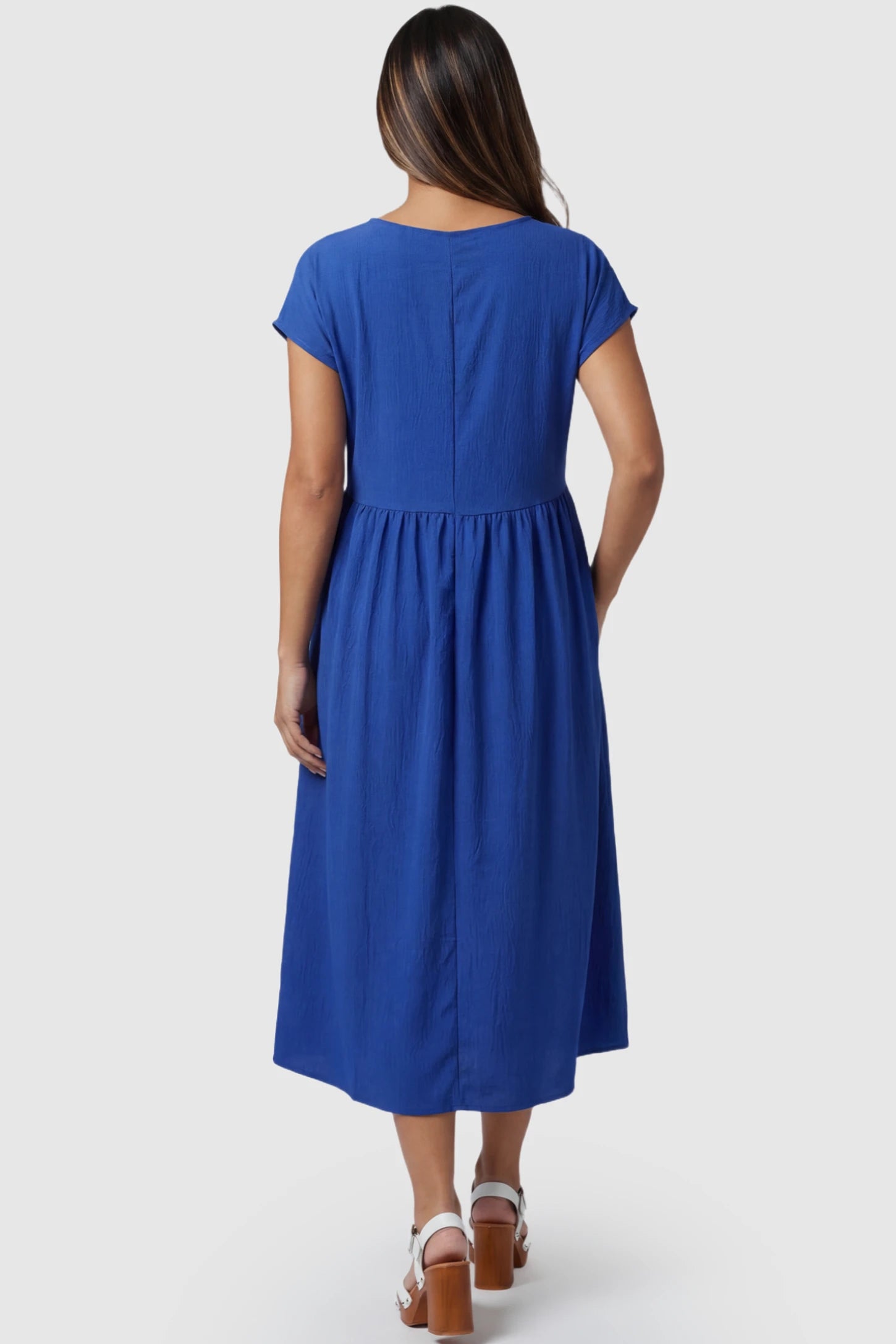 Crew Neck Short Sleeve Maternity Midi Dress Crew Neck Short Sleeve Maternity Midi Dress in Blue featuring a flowy shift silhouette on a pregnant model, back view.