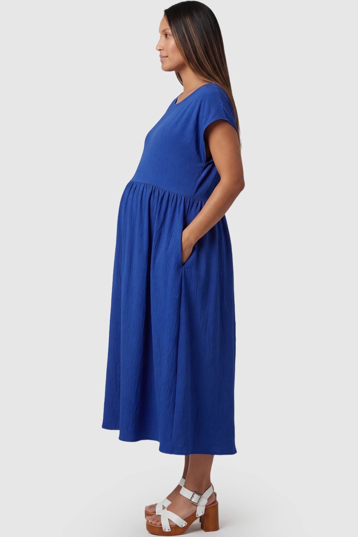 Crew Neck Short Sleeve Maternity Midi Dress Crew Neck Short Sleeve Maternity Midi Dress in Blue featuring a flowy shift silhouette on a pregnant model, side view.