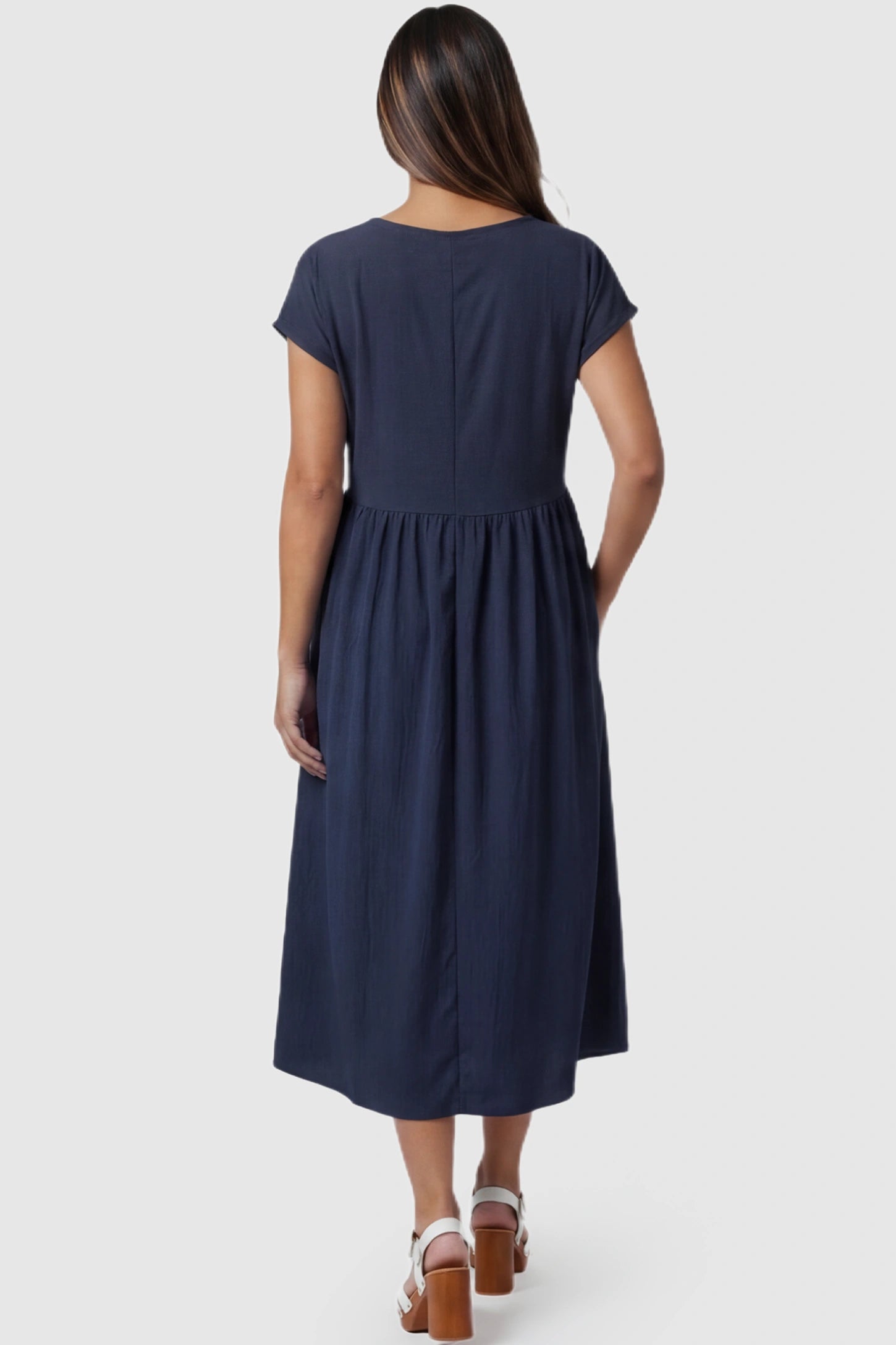 Crew Neck Short Sleeve Maternity Midi Dress Crew Neck Short Sleeve Maternity Midi Dress in Navy blue featuring a flowy shift silhouette on a pregnant model, back view.