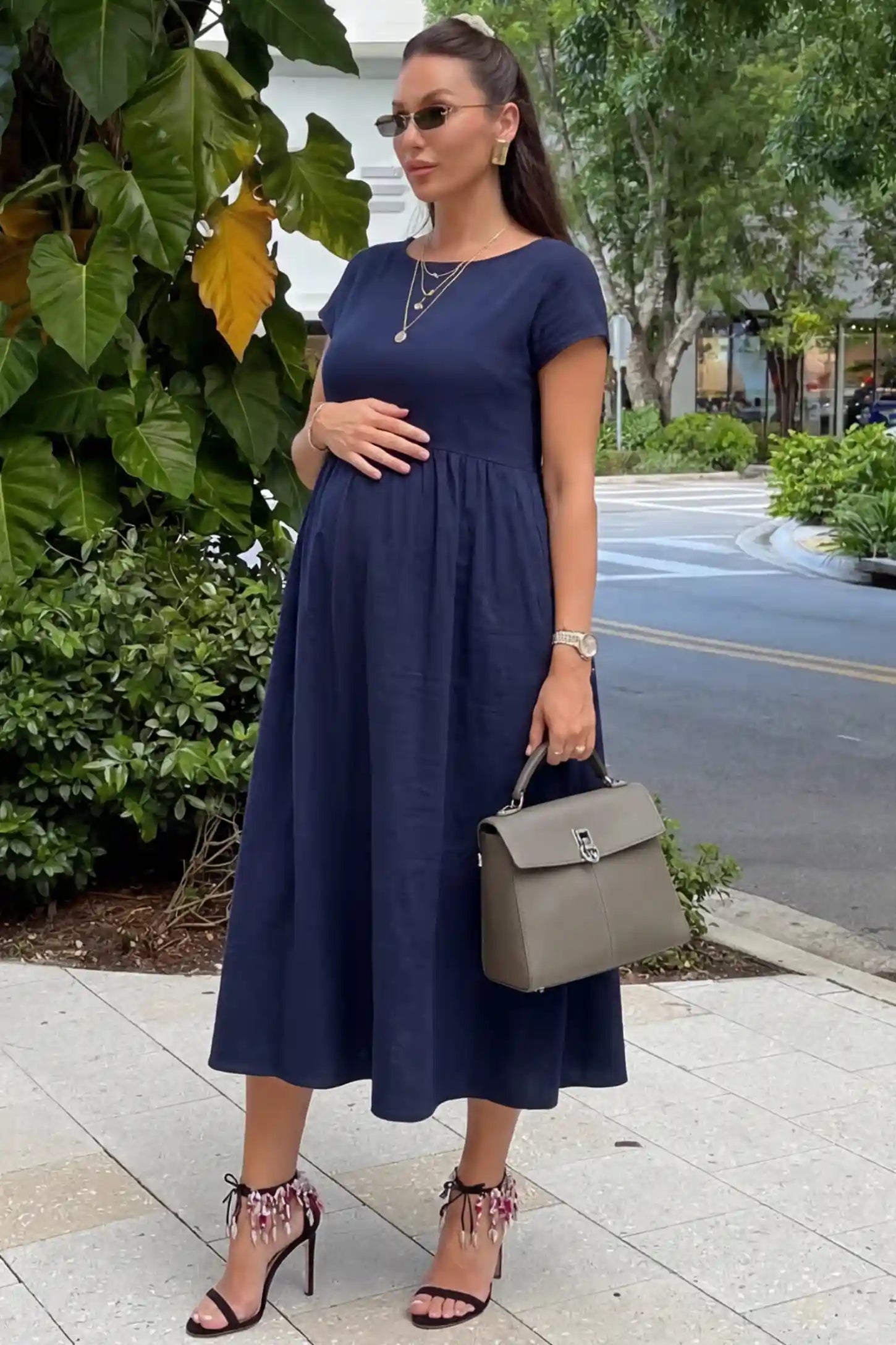 Crew Neck Short Sleeve Maternity Midi Dress in Navy blue featuring a flowy shift silhouette on a pregnant woman, side view.