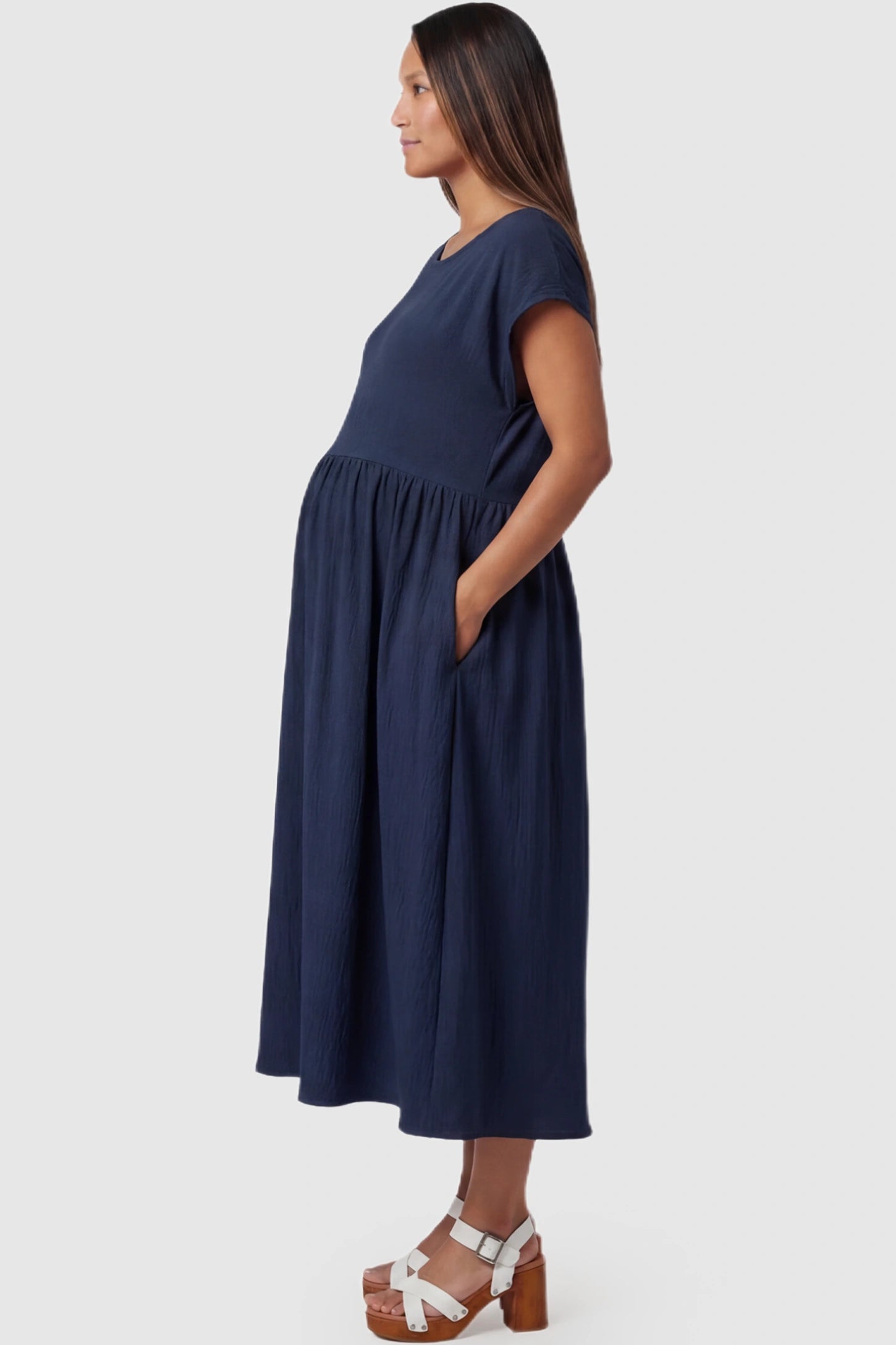 Crew Neck Short Sleeve Maternity Midi Dress Crew Neck Short Sleeve Maternity Midi Dress in Navy blue featuring a flowy shift silhouette on a pregnant model, side view.