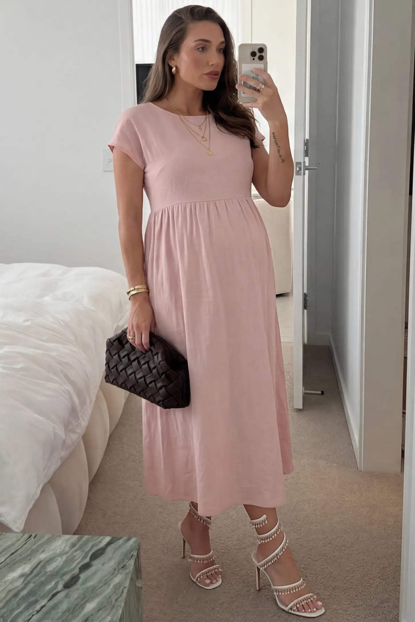 Crew Neck Short Sleeve Maternity Midi Dress Crew Neck Short Sleeve Maternity Midi Dress in Pink featuring a flowy shift silhouette on a pregnant woman, front view.