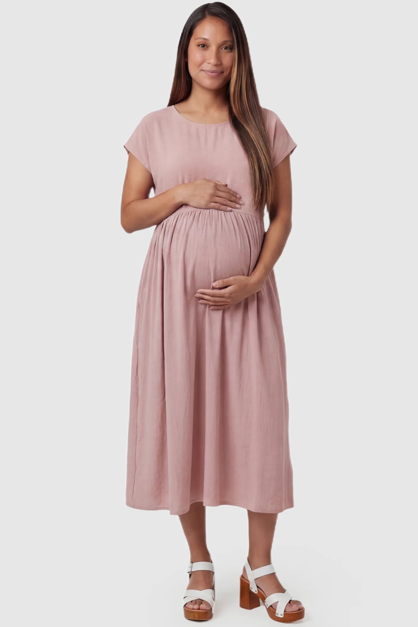 Crew Neck Short Sleeve Maternity Midi Dress Crew Neck Short Sleeve Maternity Midi Dress in Pink featuring a flowy shift silhouette on a pregnant model, front view.