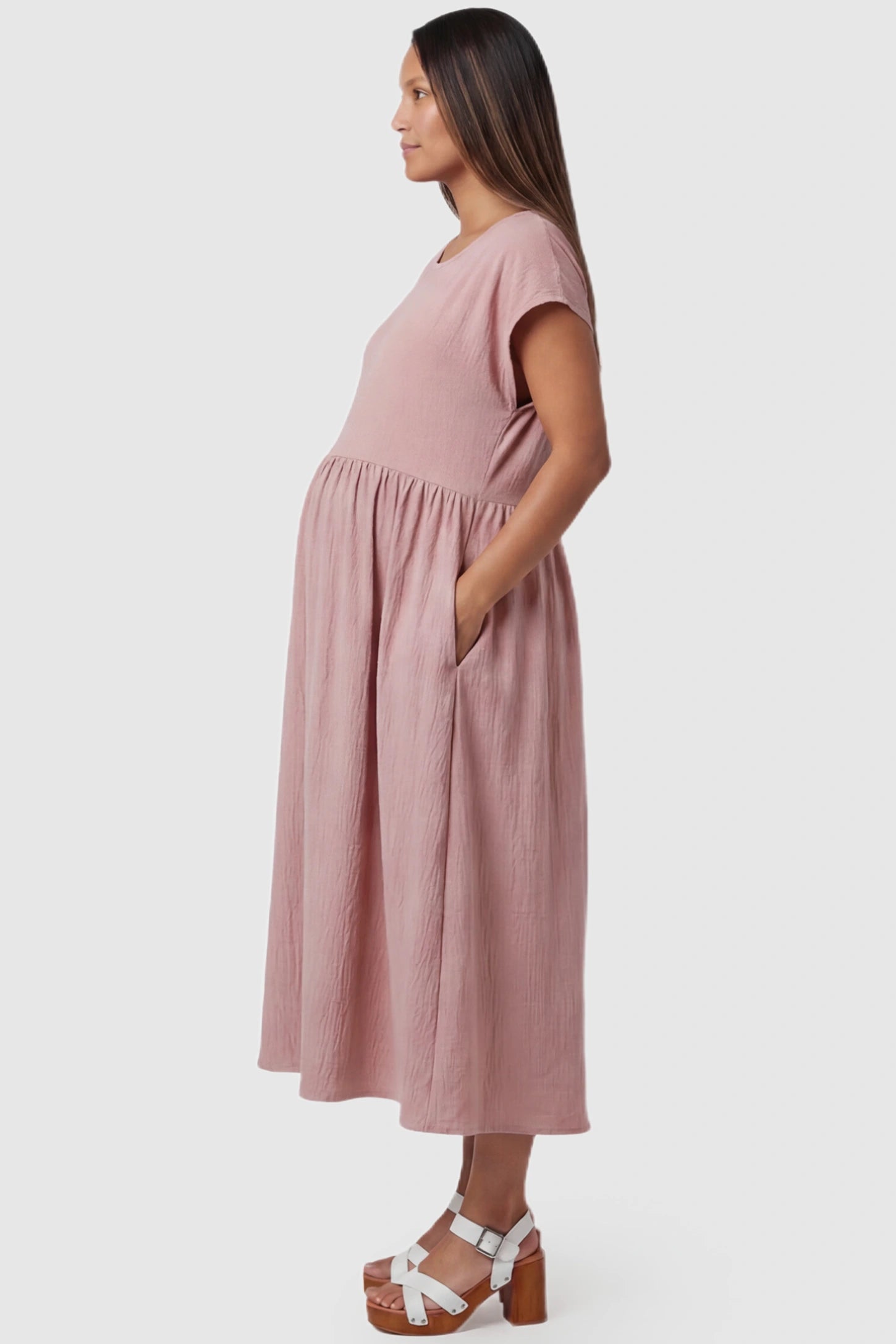 Crew Neck Short Sleeve Maternity Midi Dress Crew Neck Short Sleeve Maternity Midi Dress in Pink featuring a flowy shift silhouette on a pregnant model, side view.