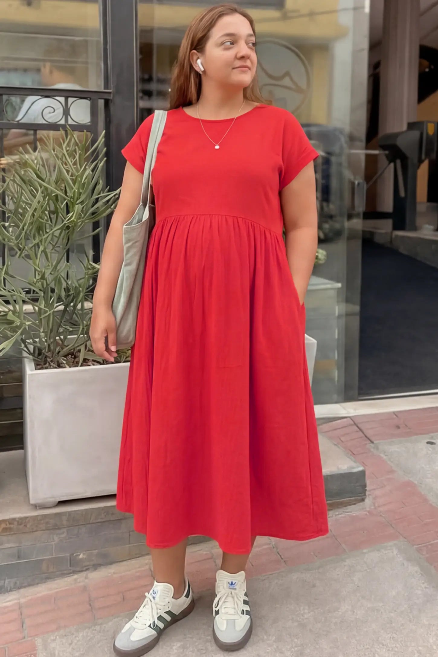 Crew Neck Short Sleeve Maternity Midi Dress Crew Neck Short Sleeve Maternity Midi Dress in Red featuring a flowy shift silhouette on a pregnant woman, front view.