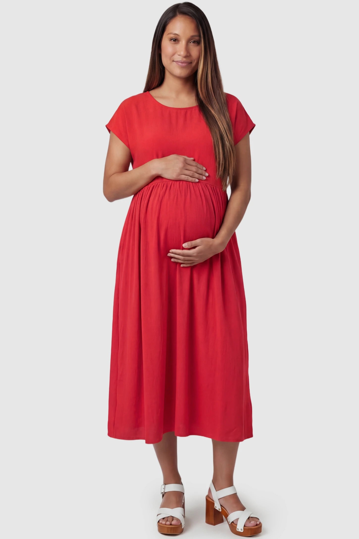 Crew Neck Short Sleeve Maternity Midi Dress Crew Neck Short Sleeve Maternity Midi Dress in Red featuring a flowy shift silhouette on a pregnant model, front view.