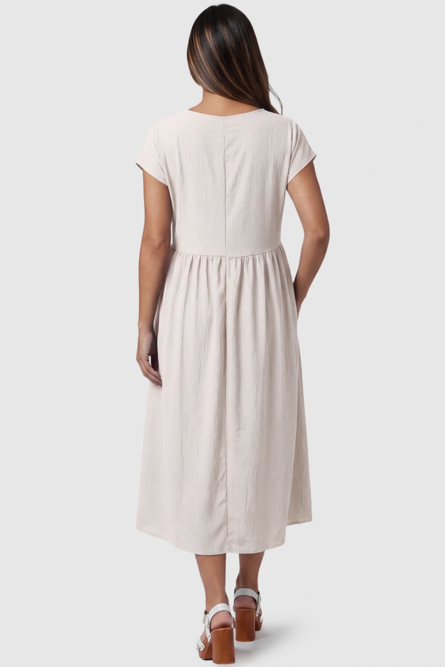 Crew Neck Short Sleeve Maternity Midi Dress Crew Neck Short Sleeve Maternity Midi Dress in White featuring a flowy shift silhouette on a pregnant model, back view.