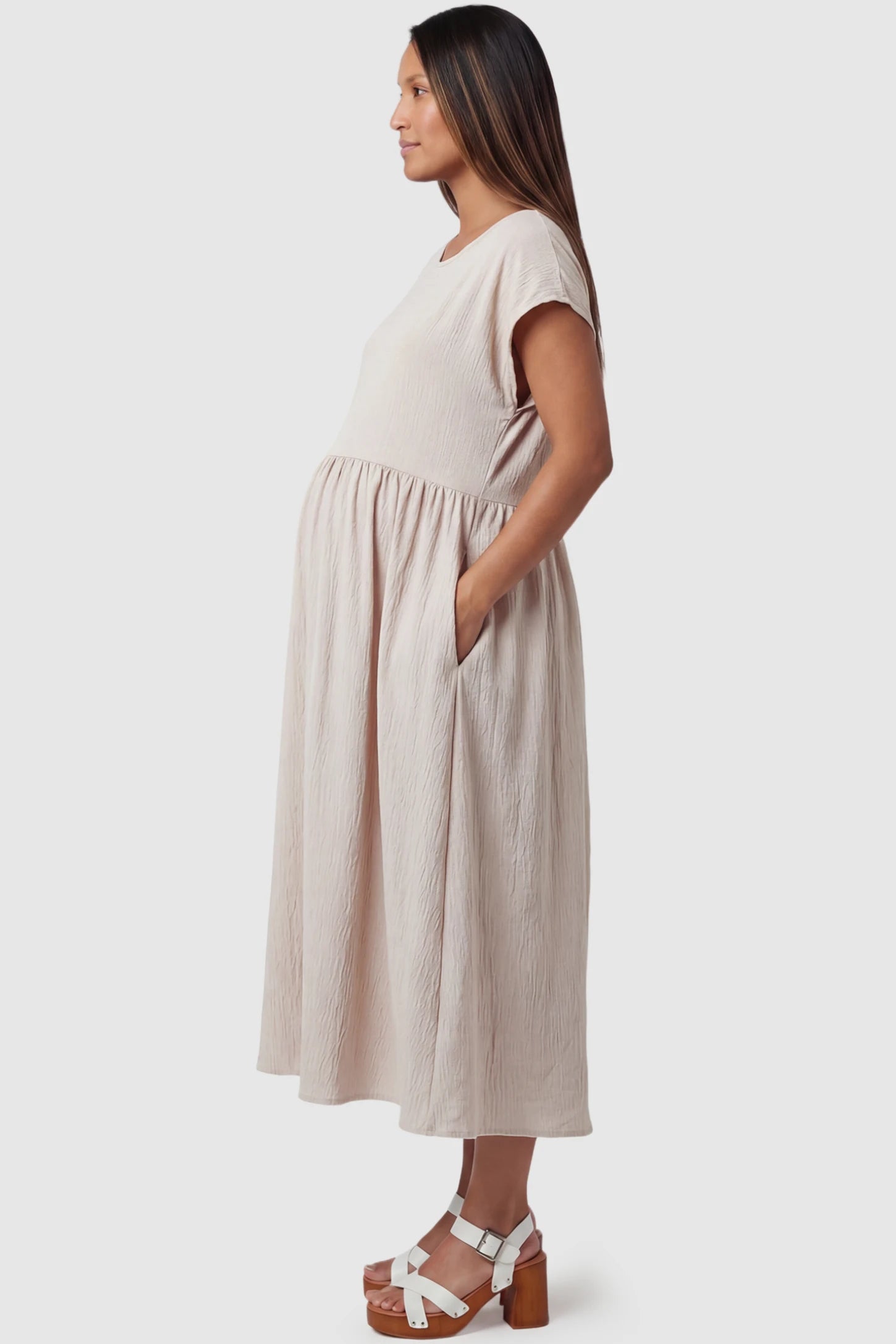 Crew Neck Short Sleeve Maternity Midi Dress Crew Neck Short Sleeve Maternity Midi Dress in White featuring a flowy shift silhouette on a pregnant model, side view.
