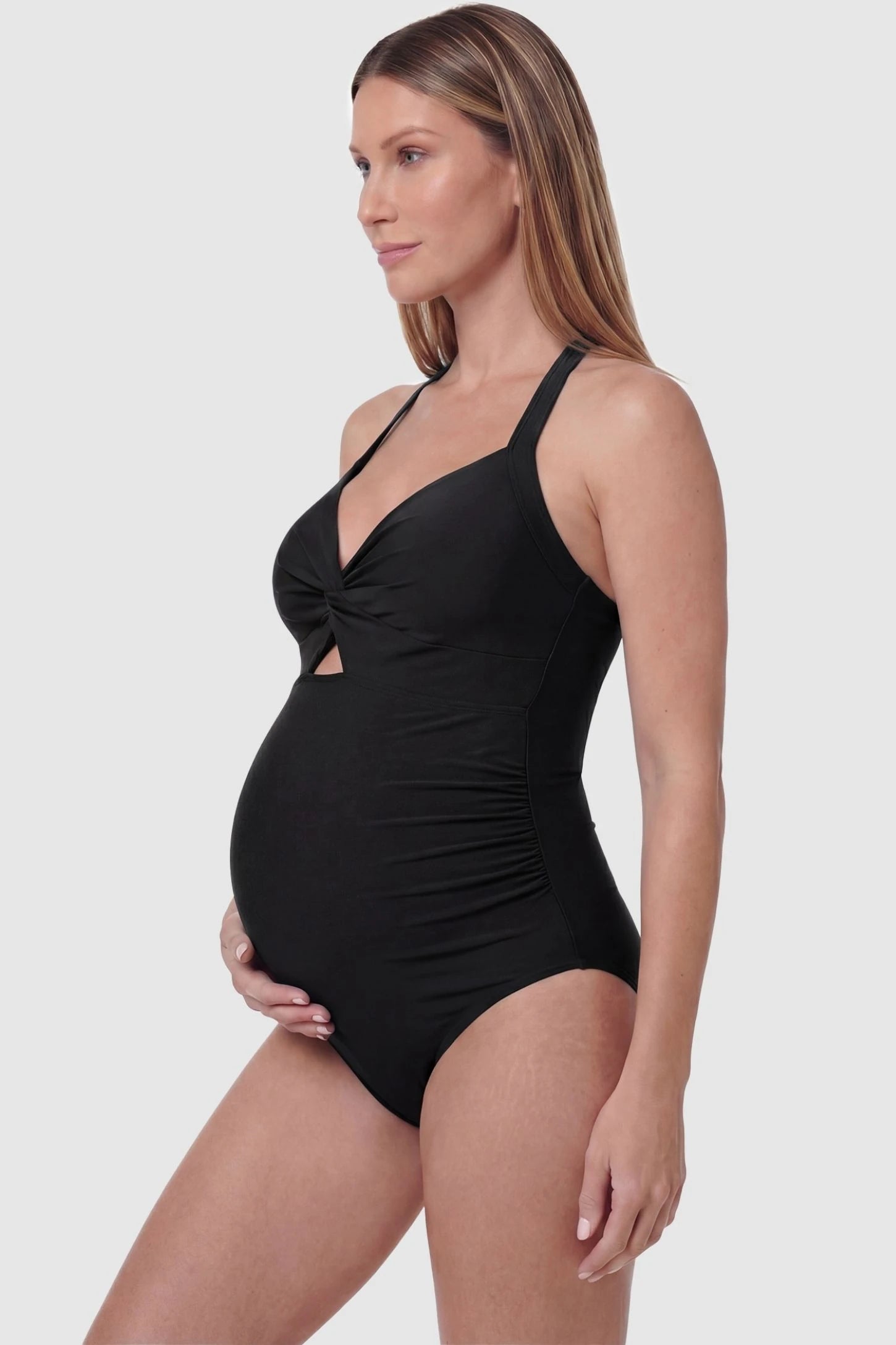 Criss-Cross Back Twist-Front Maternity One-Piece Criss-Cross Back Twist-Front Maternity One-Piece in Black featuring flattering side ruching on a pregnant model, side view.