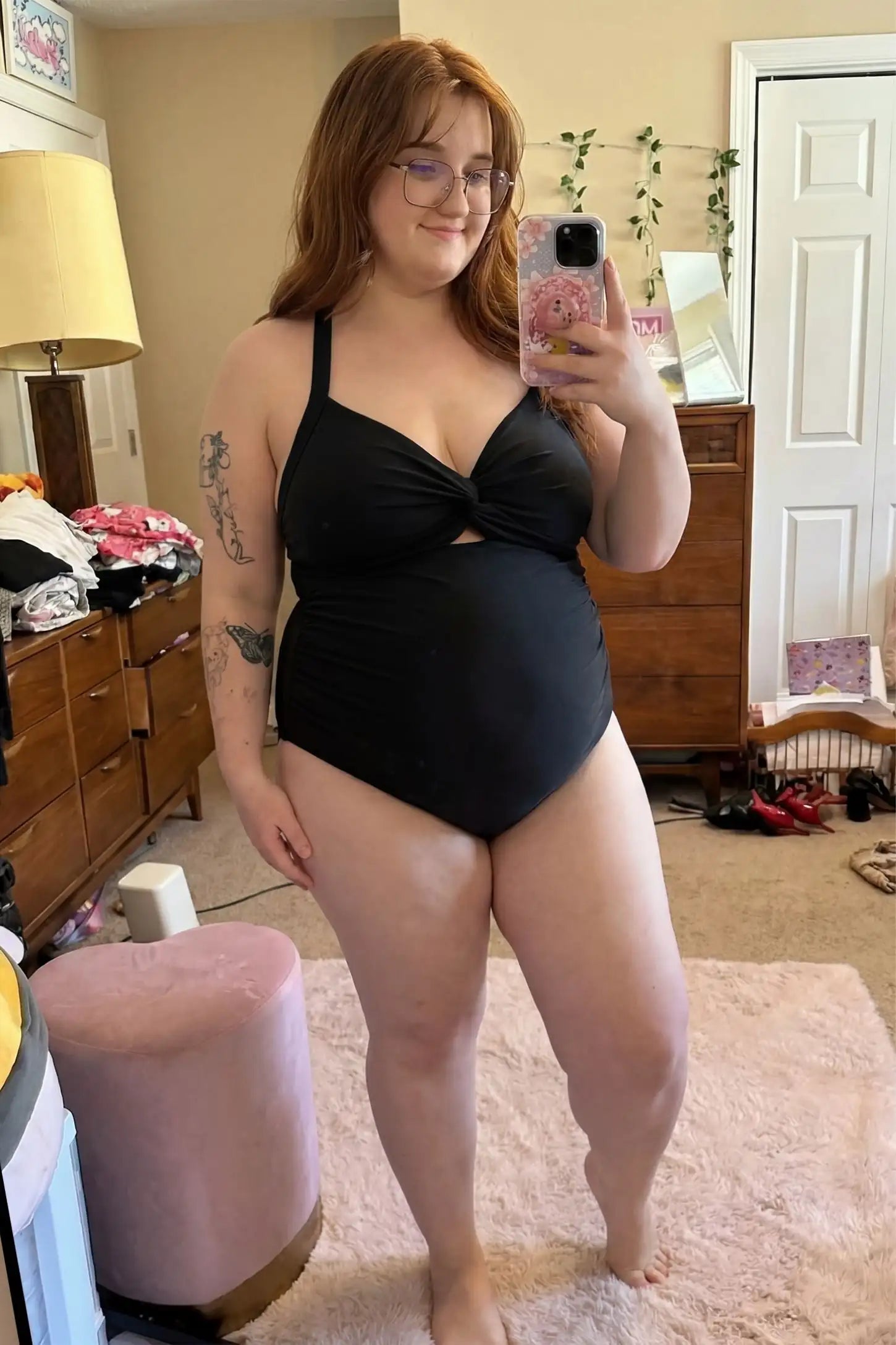 Criss-Cross Back Twist-Front Maternity One-Piece Criss-Cross Back Twist-Front Maternity One-Piece in Black featuring high-stretch fabric on a pregnant model in a mirror selfie.