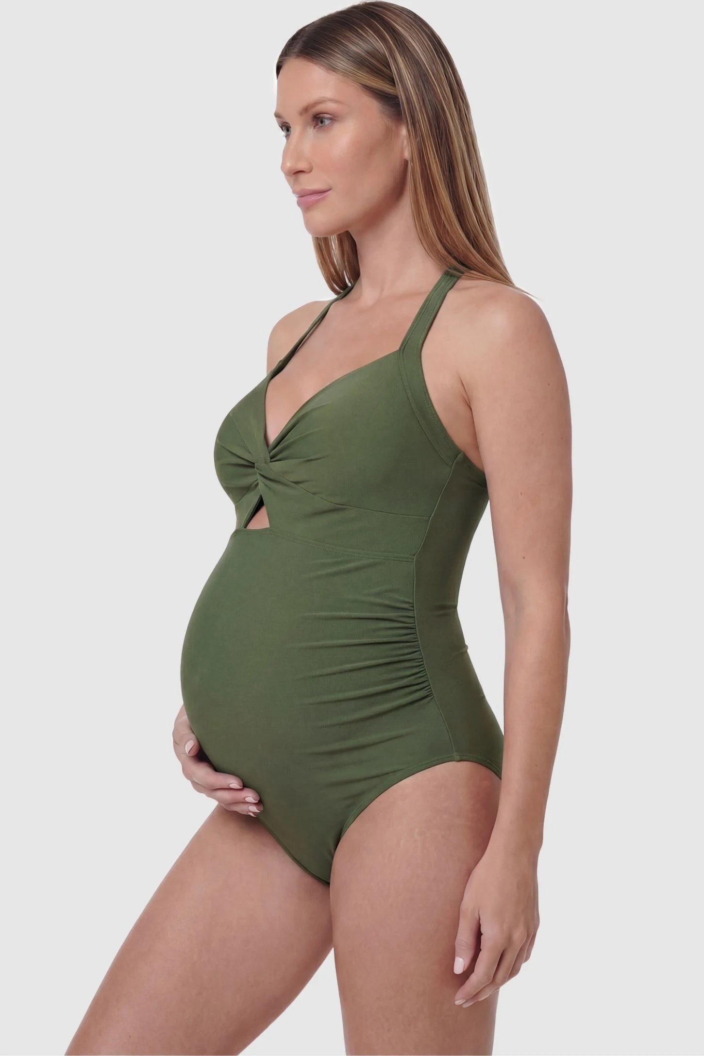 Criss-Cross Back Twist-Front Maternity One-Piece Criss-Cross Back Twist-Front Maternity One-Piece in Green featuring flattering side ruching on a pregnant model, side view.