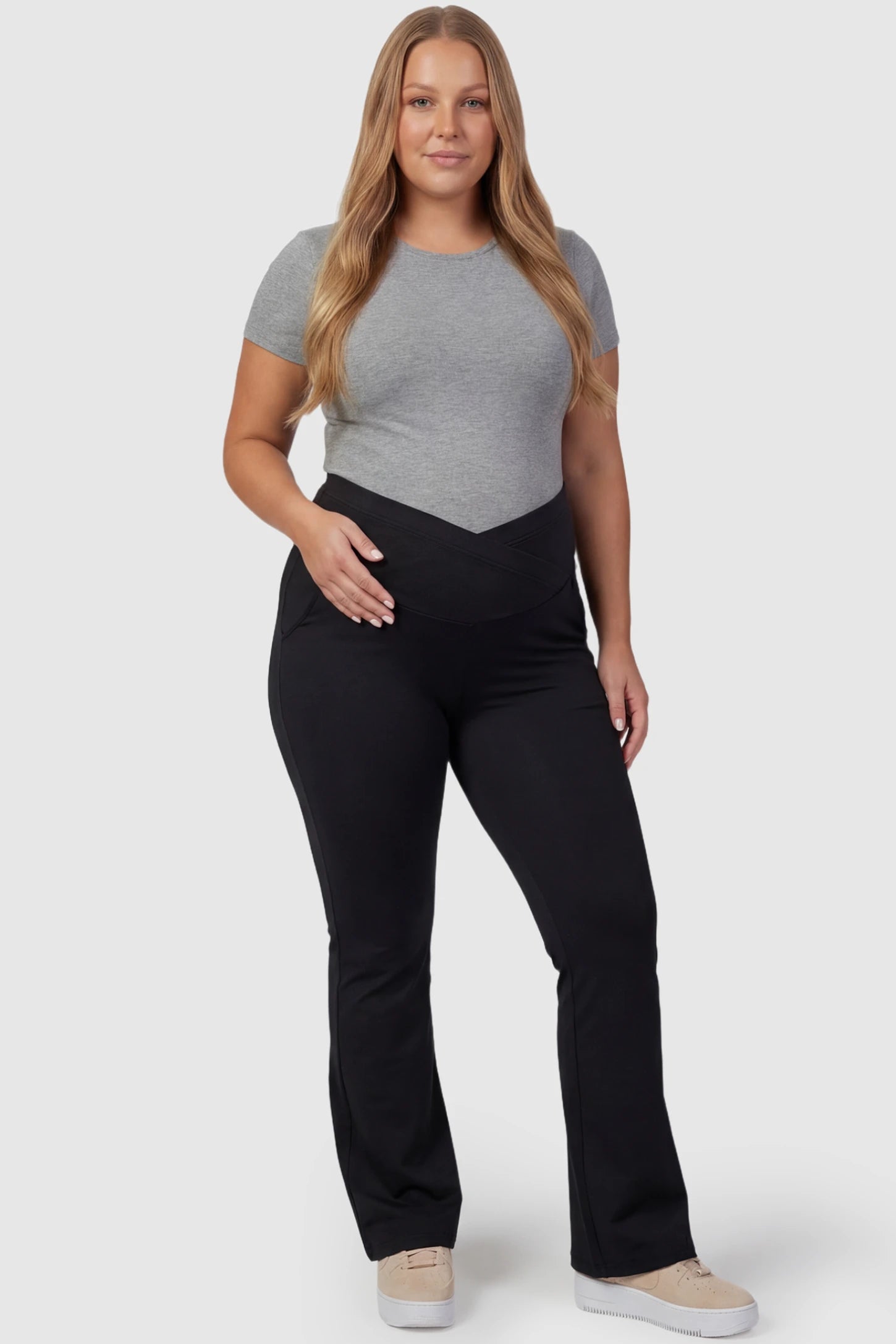 Crossover Waistline Flared Maternity Pants Crossover Waistline Flared Maternity Pants in Black featuring a V-shaped band on a plus size pregnant model, front view.