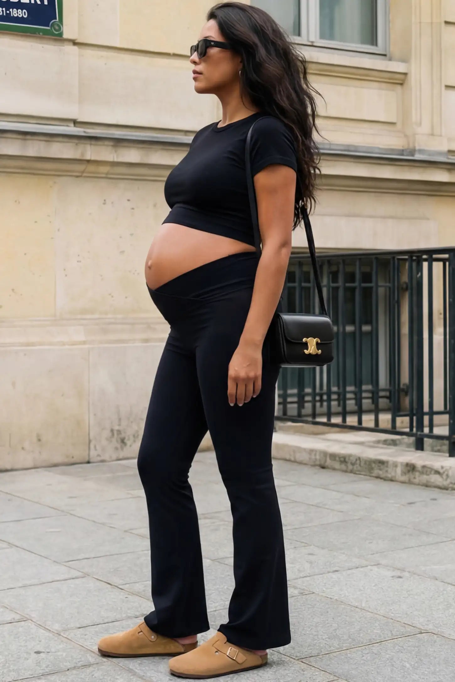 Crossover Waistline Flared Maternity Pants Crossover Waistline Flared Maternity Pants in Black featuring a V-shaped band on a pregnant woman, side view.