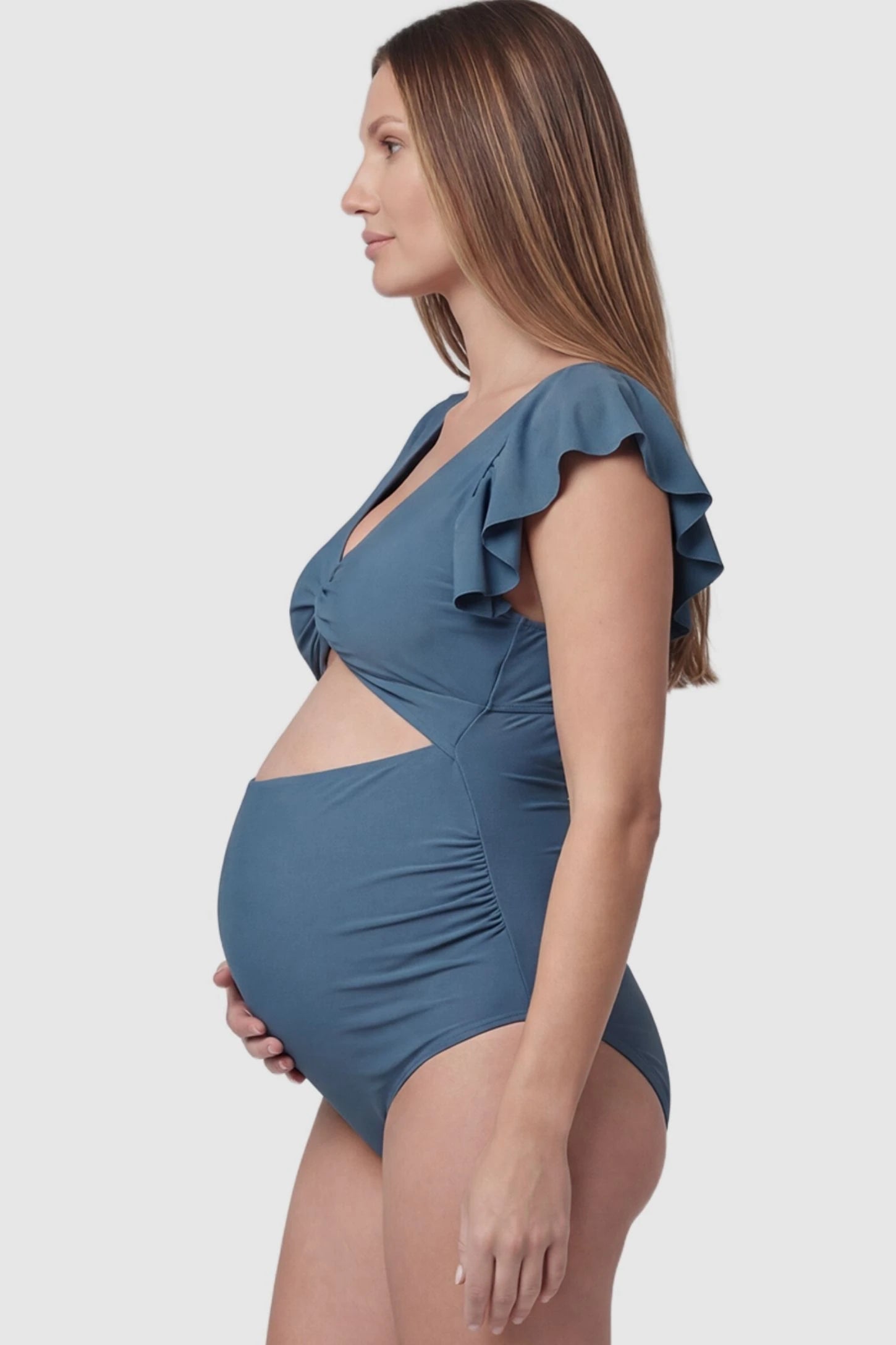 Cutout Twist-Front Maternity Monokini Cutout Twist-Front Maternity Monokini in Blue featuring flattering side ruching on a pregnant model, side view.