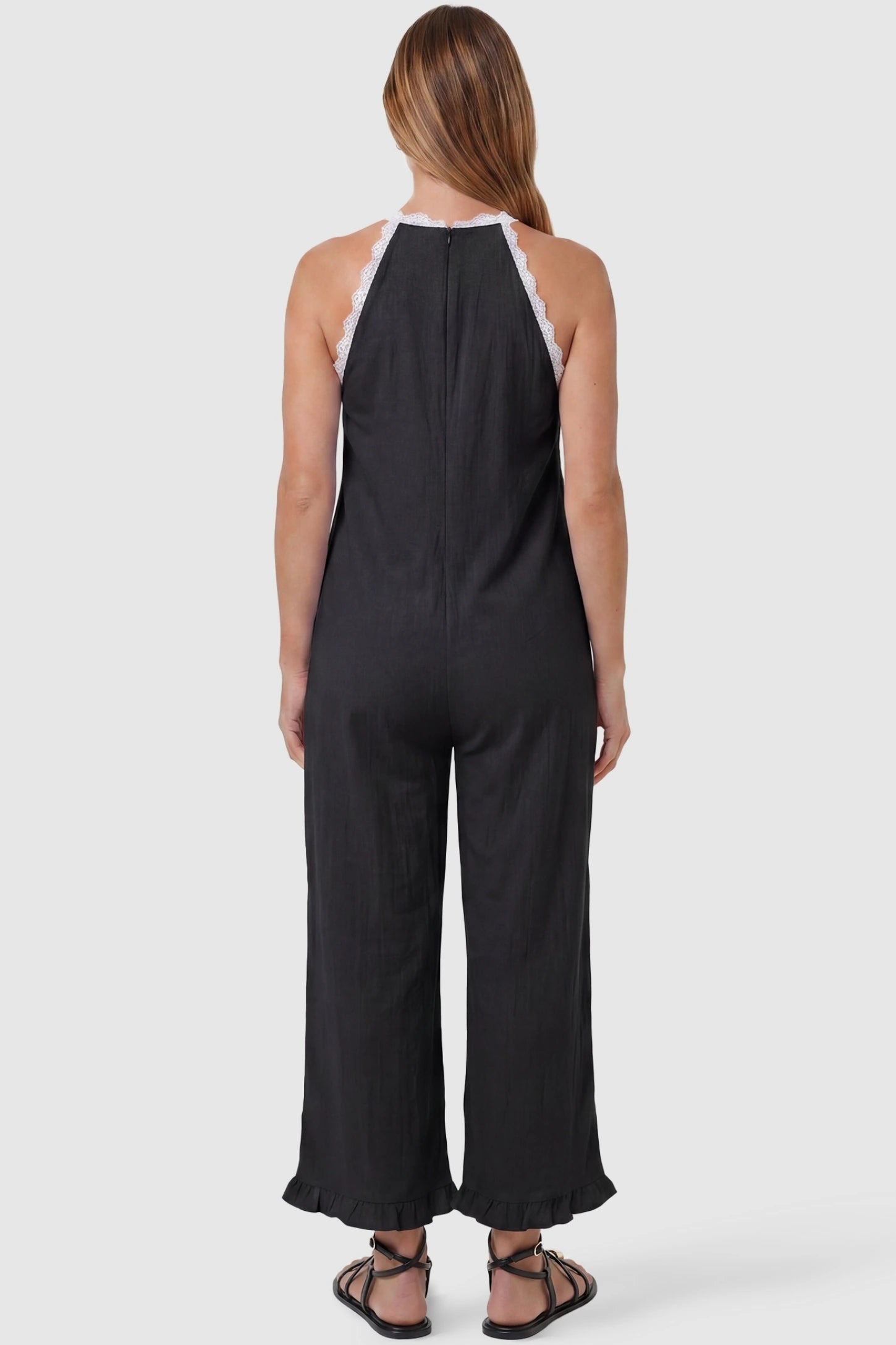 Deep V-Neck Lace Trim Wide Leg Maternity Jumpsuit Deep V-Neck Lace Trim Wide Leg Maternity Jumpsuit in Black featuring an open back design with lace trim finish on a pregnant model, back view.