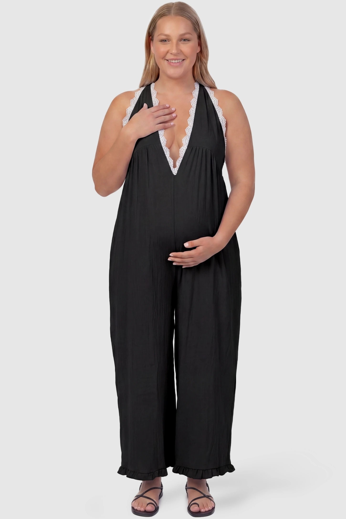 Deep V-Neck Lace Trim Wide Leg Maternity Jumpsuit Deep V-Neck Lace Trim Wide Leg Maternity Jumpsuit in Black featuring a flattering wide leg cut with lace trim neckline on a plus-size model, front view.