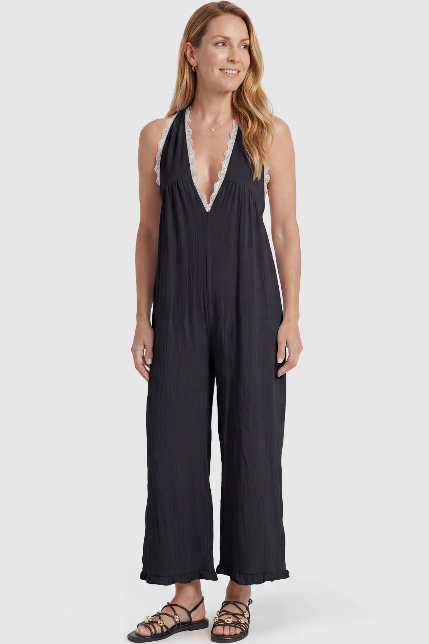 Deep V-Neck Lace Trim Wide Leg Maternity Jumpsuit Deep V-Neck Lace Trim Wide Leg Maternity Jumpsuit in Black featuring a flattering wide leg cut with lace trim neckline on a postpartum model, front view.