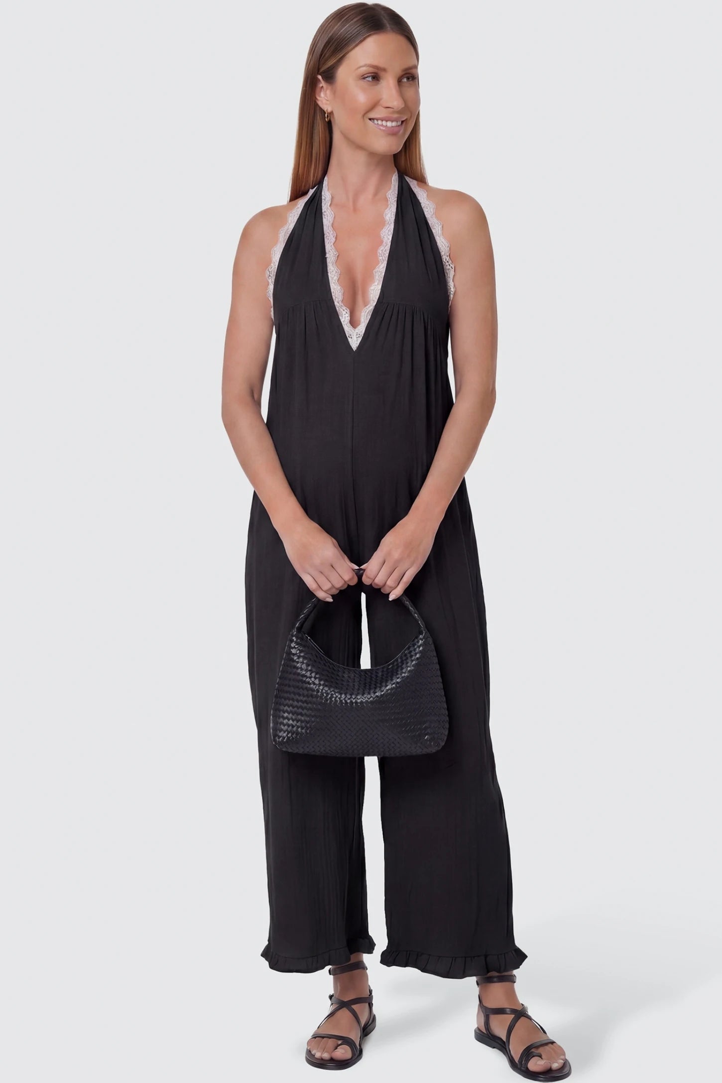Deep V-Neck Lace Trim Wide Leg Maternity Jumpsuit Deep V-Neck Lace Trim Wide Leg Maternity Jumpsuit in Black featuring a deep V-neckline with delicate lace trim on a pregnant model, front view.