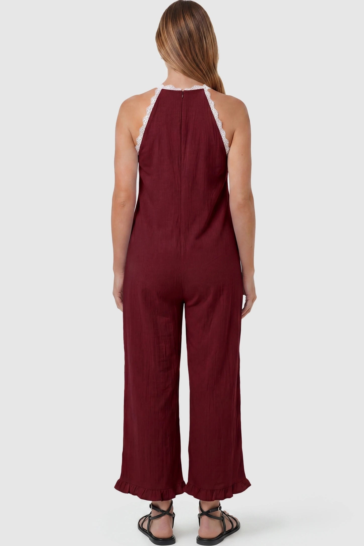 Deep V-Neck Lace Trim Wide Leg Maternity Jumpsuit Deep V-Neck Lace Trim Wide Leg Maternity Jumpsuit in Burgundy featuring an open back design with lace trim finish on a pregnant model, back view.