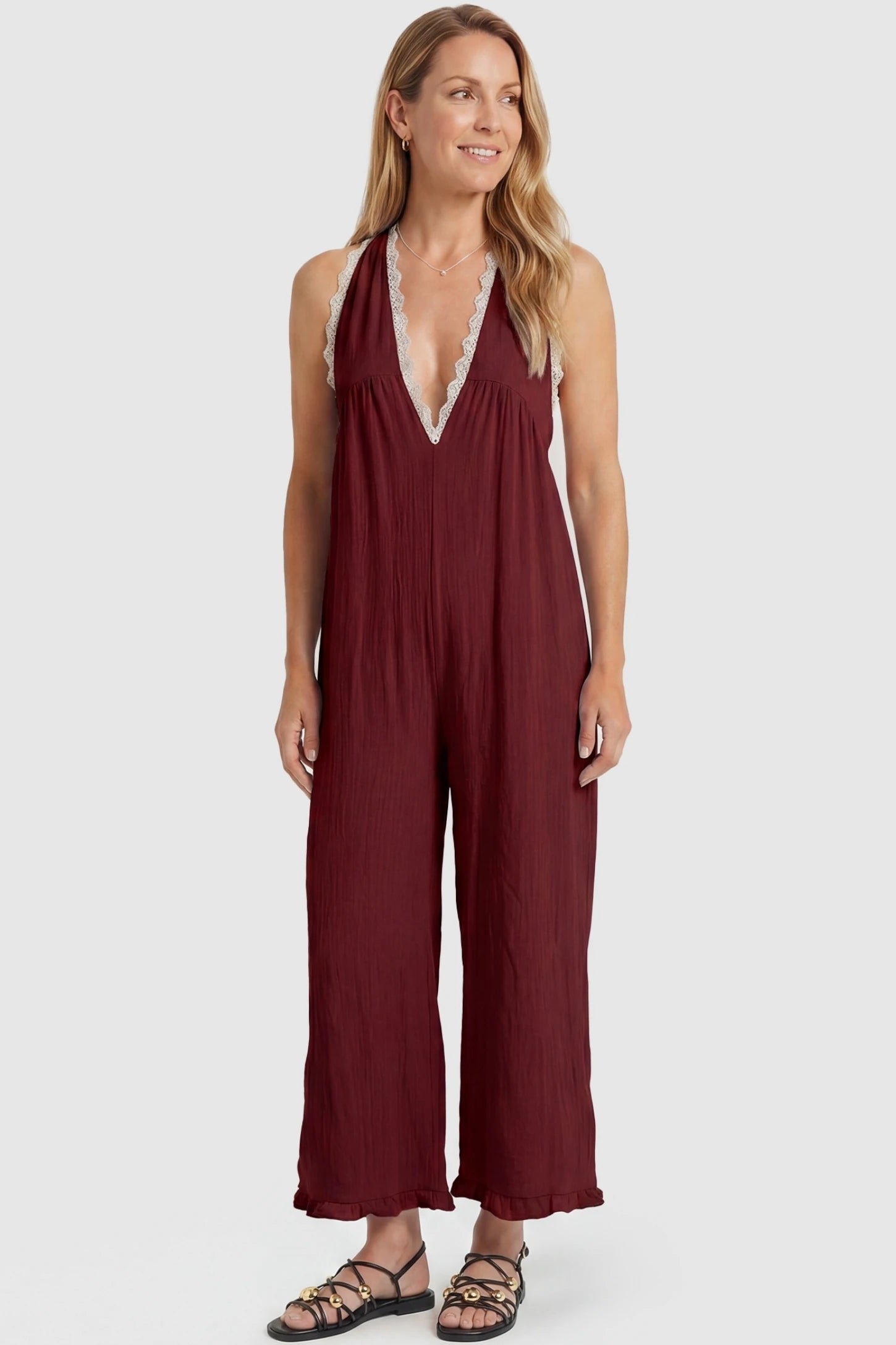 Deep V-Neck Lace Trim Wide Leg Maternity Jumpsuit Deep V-Neck Lace Trim Wide Leg Maternity Jumpsuit in Burgundy featuring a flattering wide leg cut with lace trim neckline on a postpartum model, front view.